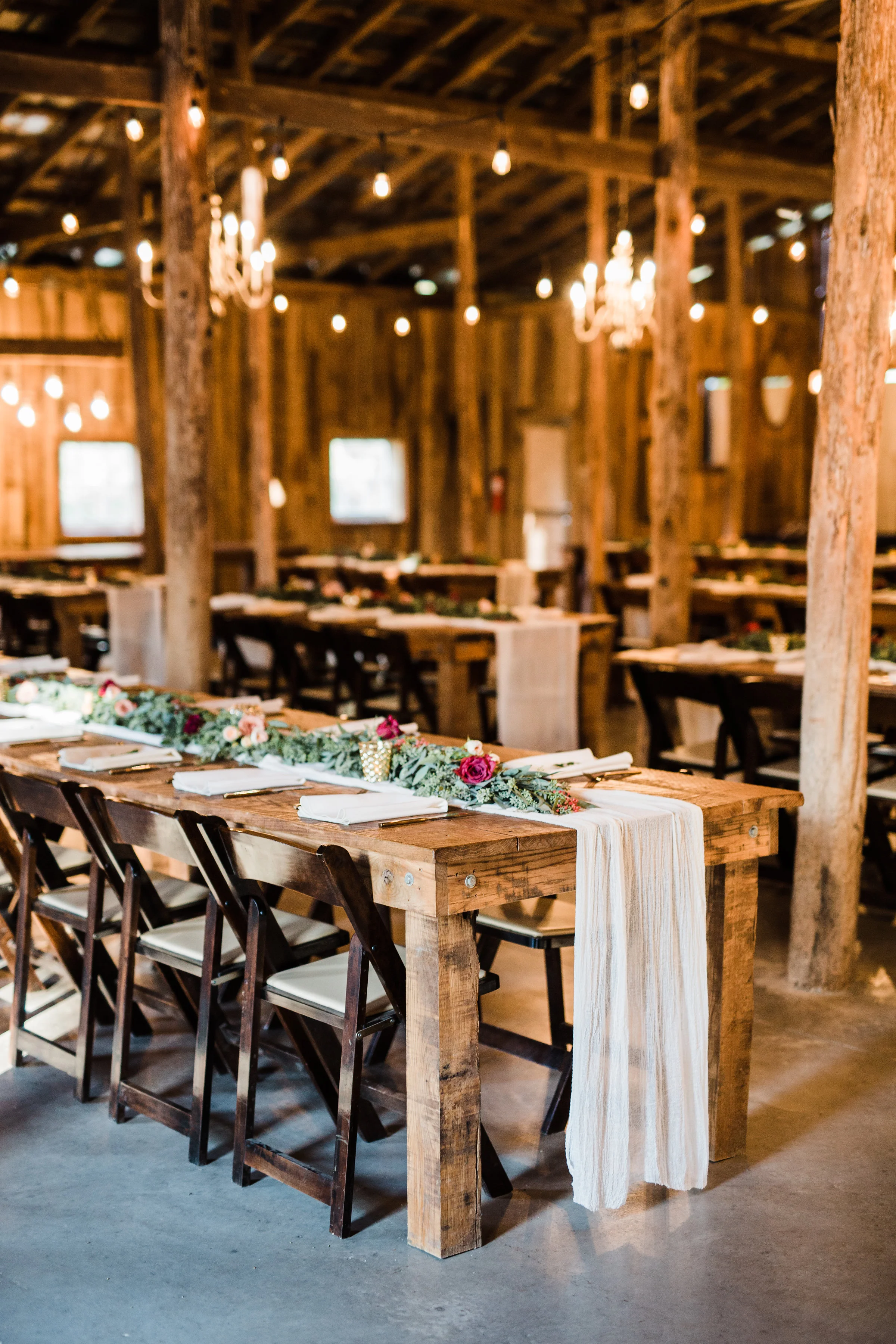 Barn reception with lush greenery table runners // Nashville Wedding Florist