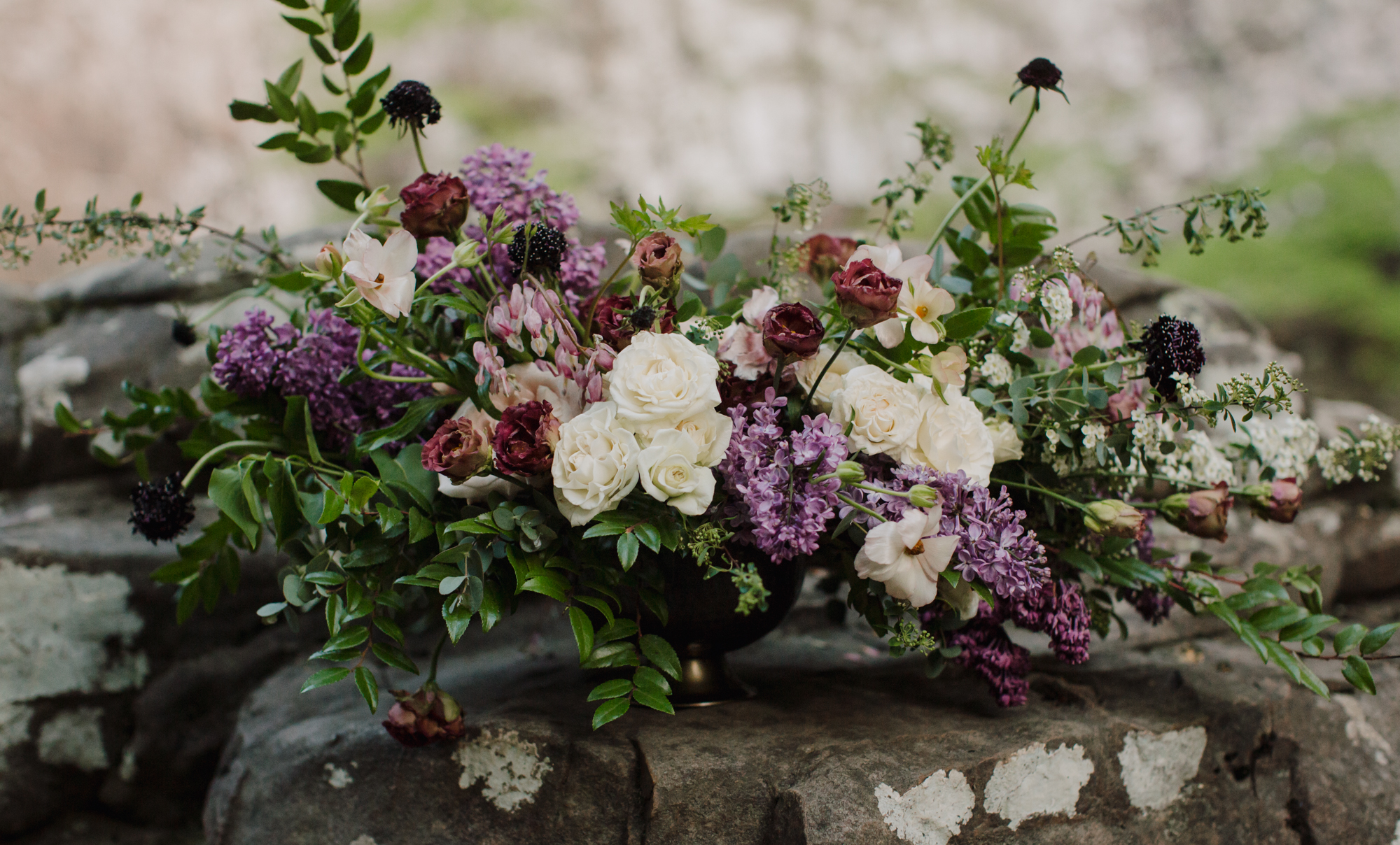 Lush floral centerpiece with lilacs, bleeding hearts, and butterfly ranunculus // Waterfall Vow Renewal in Middle Tennessee