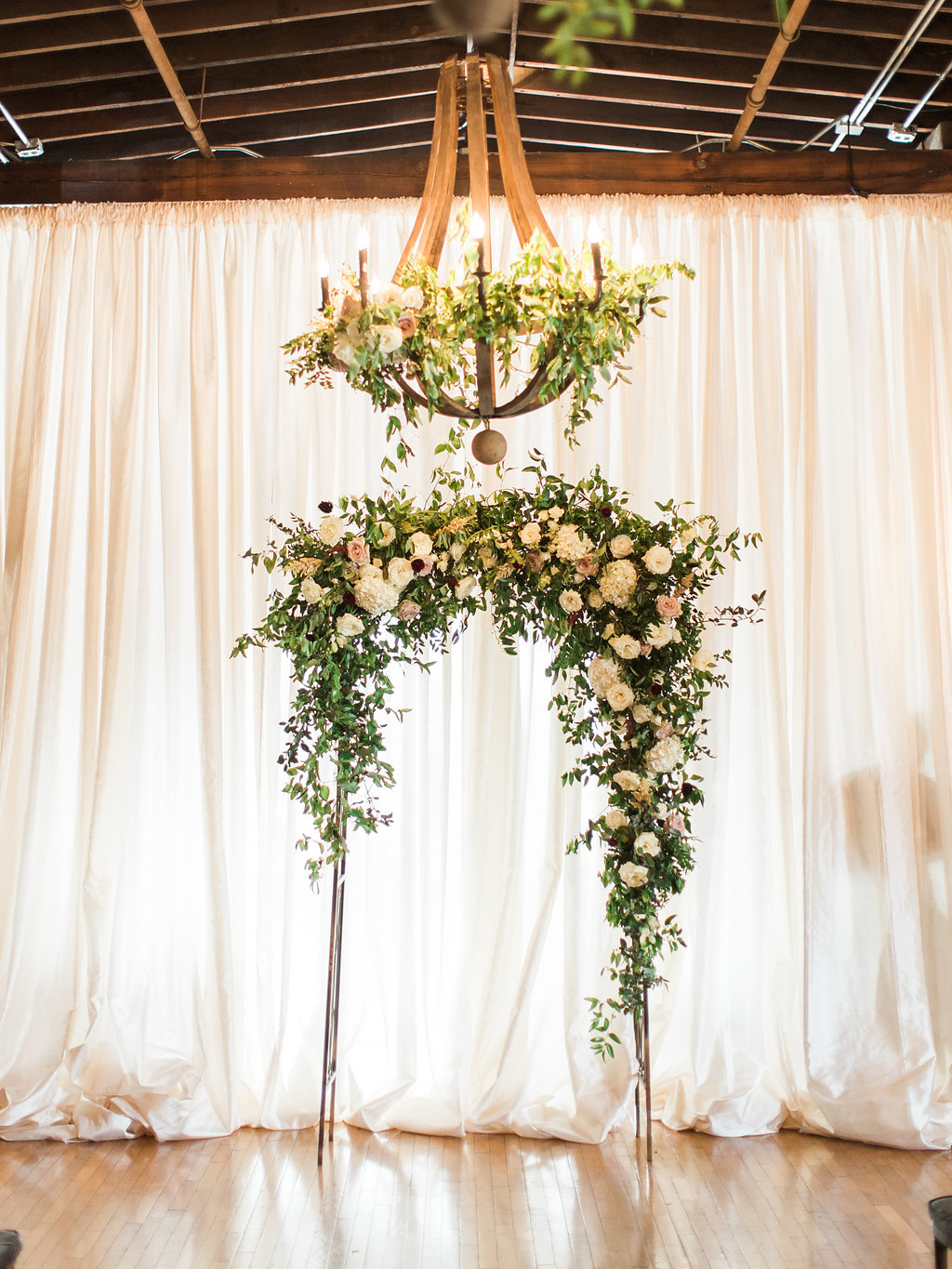 Lush wedding ceremony arch with natural greenery, blush and white flowers, and hints of marsala and burgundy // Nashville, TN Wedding Floral Design