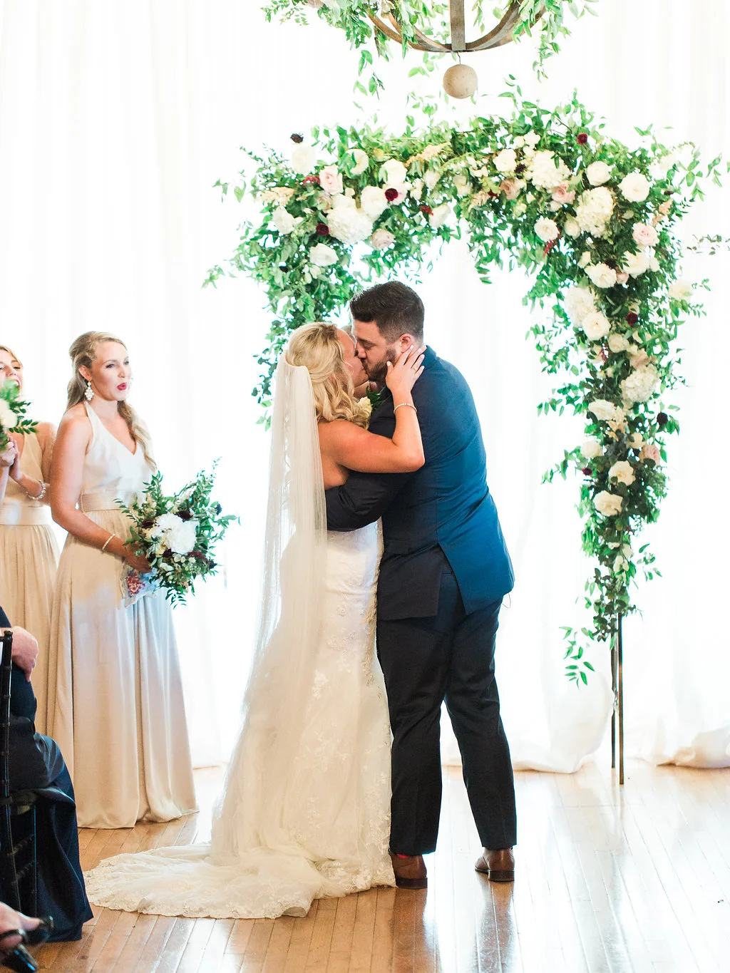 Lush wedding ceremony arch with natural greenery, blush and white flowers, and hints of marsala and burgundy // Nashville, TN Wedding Floral Design