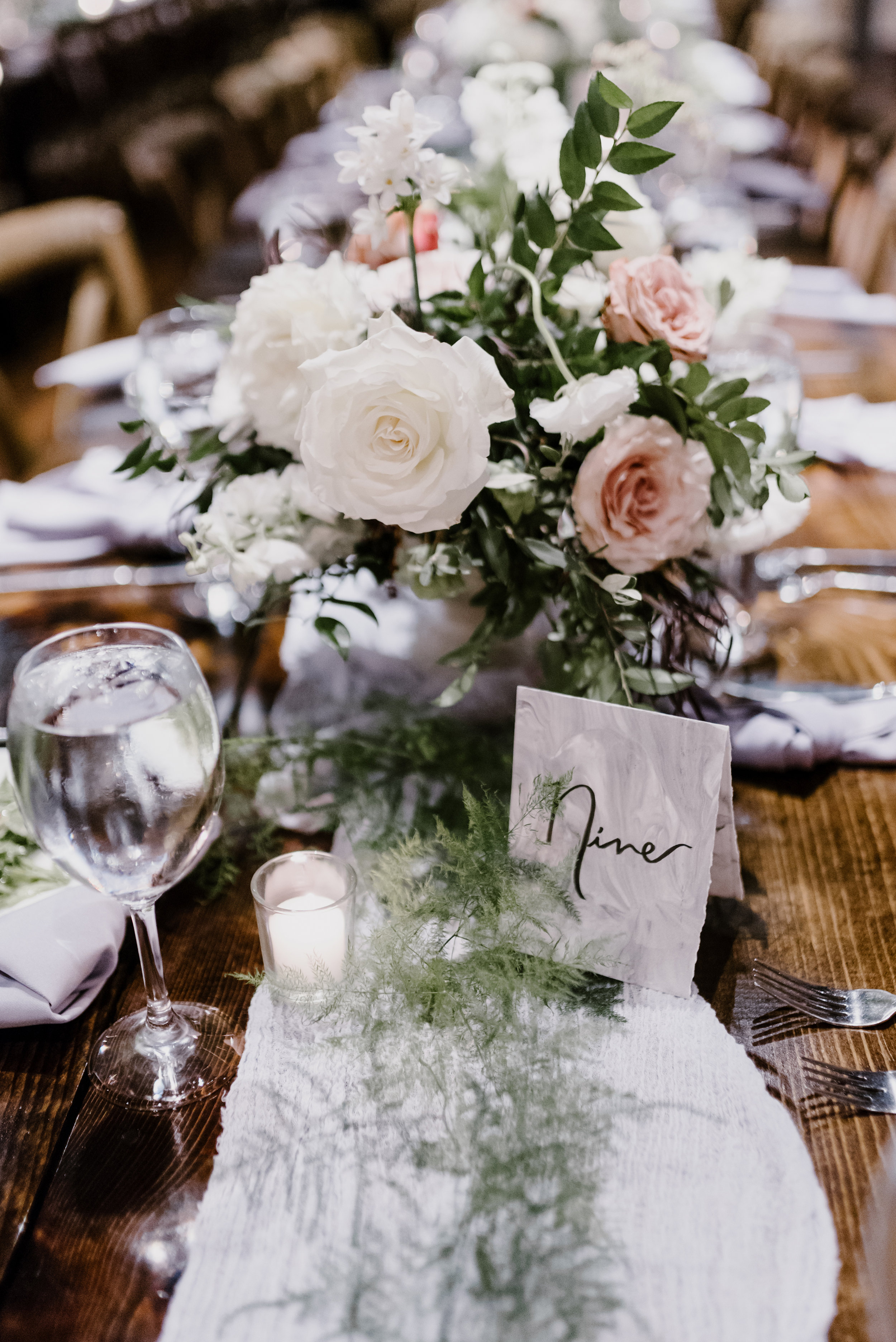 Low, overflowing centerpiece with soft grey runners and light, airy greenery // Cordelle Wedding Flowers
