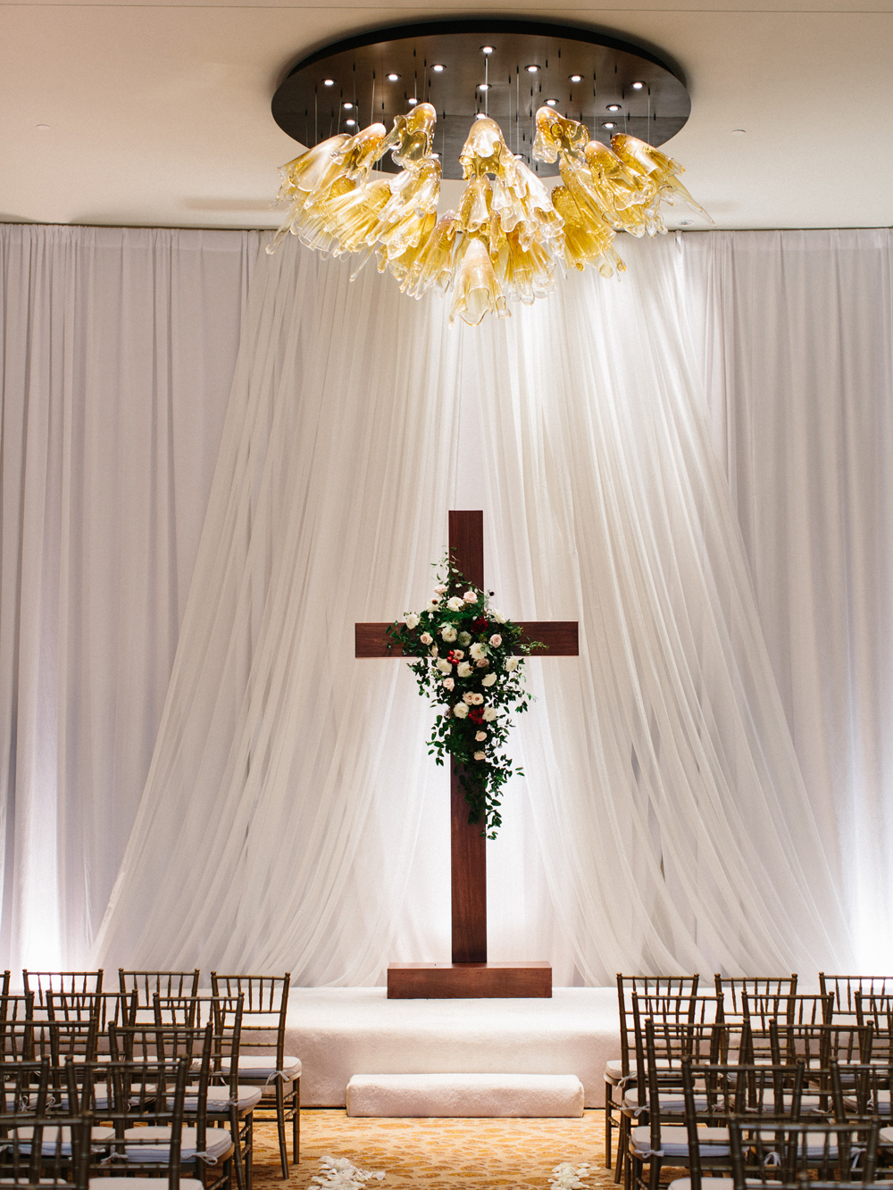 Wooden cross backdrop with lush floral spray // Elegant downtown Nashville wedding flowers