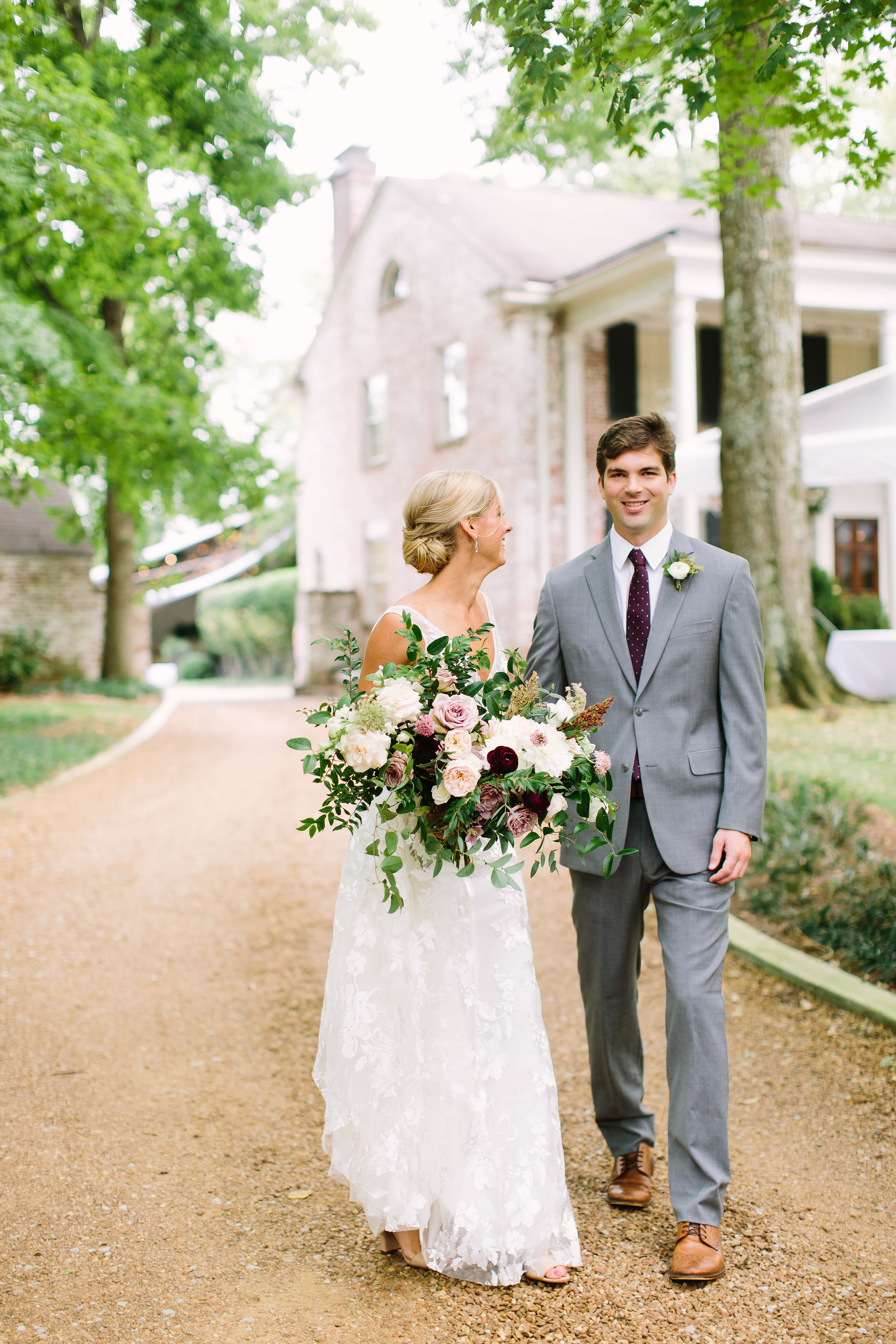 Natural, asymmetrical bridal bouquet with soft mauve garden roses, eggplant ranunculus, and trailing greenery // Nashville Wedding Floral Design
