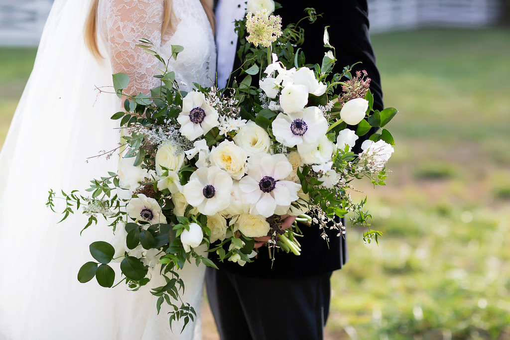 Oversized, asymmetrical bride’s bouquet with white flowers and natural, untamed greenery // Southeastern Wedding Floral Design at Blackberry Farm