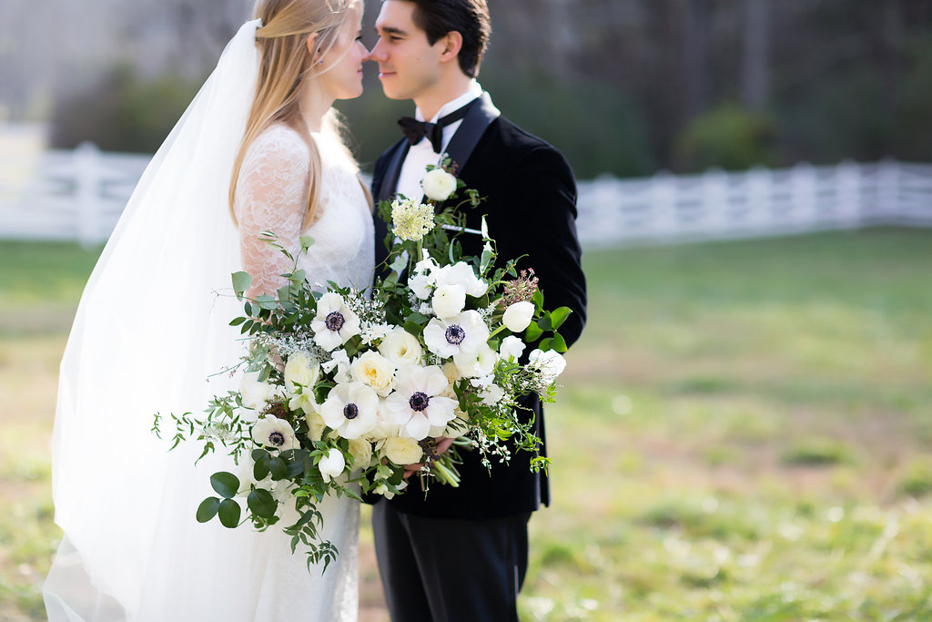 Oversized, asymmetrical bride’s bouquet with white flowers and natural, untamed greenery // Southeastern Wedding Floral Design at Blackberry Farm