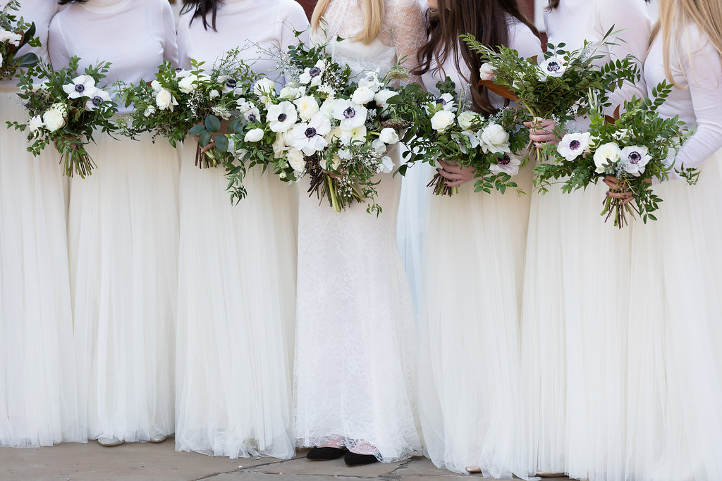 All white bridesmaid style with cashmere turtlenecks, tulle skirts, and loose bouquets of white florals and natural greenery // Nashville Wedding Flowers