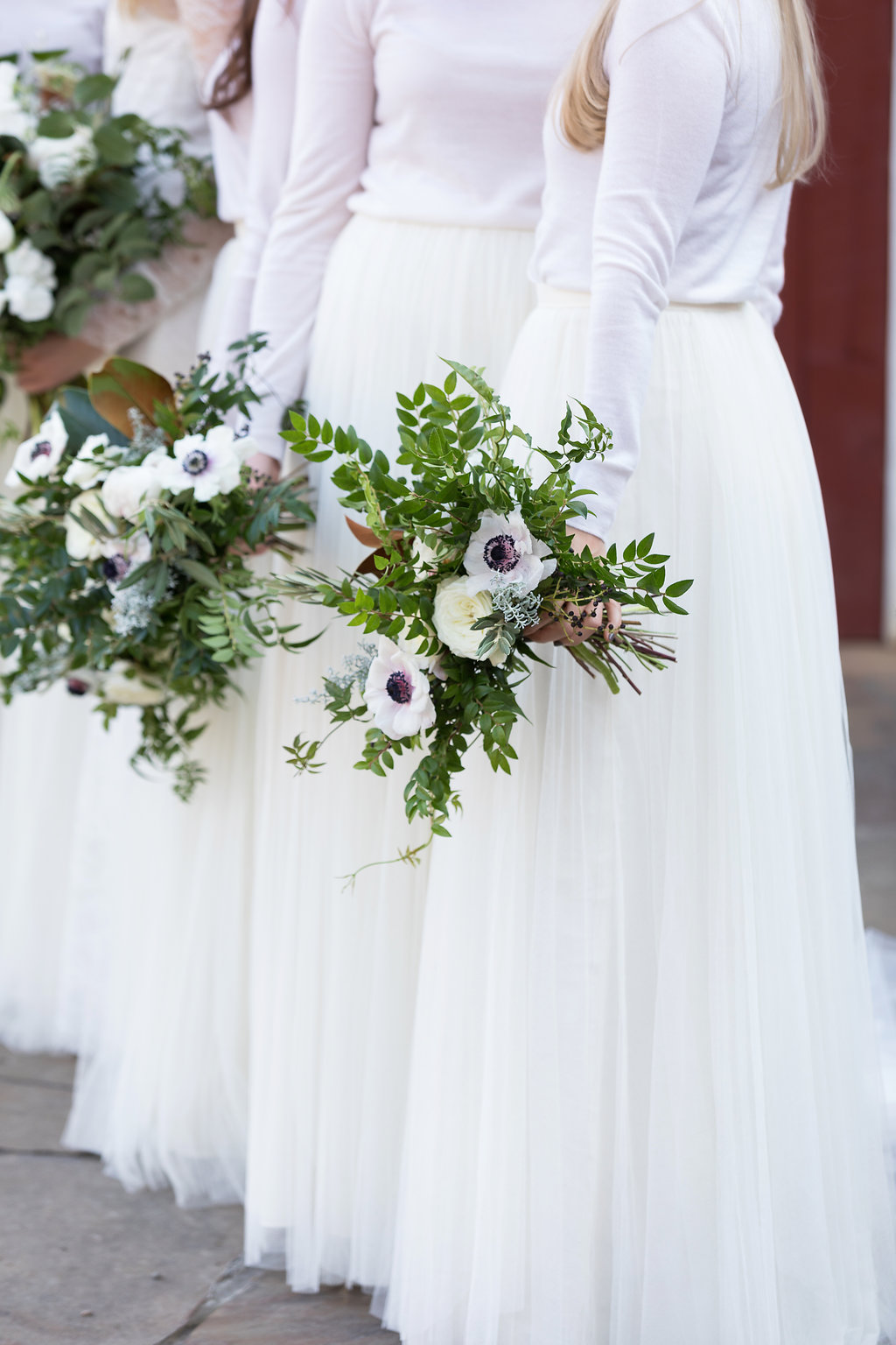 All white bridesmaid style with cashmere turtlenecks, tulle skirts, and loose bouquets of white florals and natural greenery // Nashville Wedding Flowers