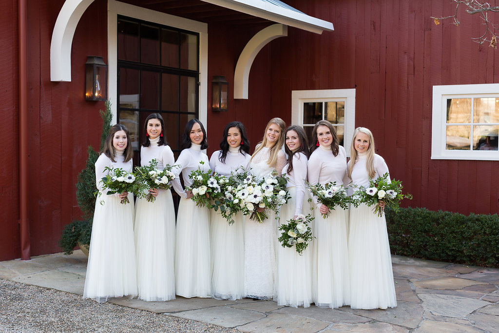 All white bridesmaid style with cashmere turtlenecks, tulle skirts, and loose bouquets of white florals and natural greenery // Nashville Wedding Flowers