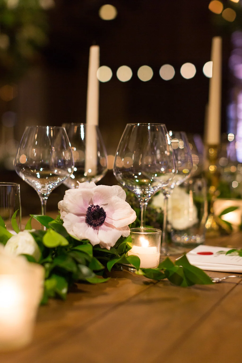 Lush greenery garland runners with floral accents of anemones and white garden roses on farm tables // Nashville Wedding Florist // Rosemary & Finch Floral Design