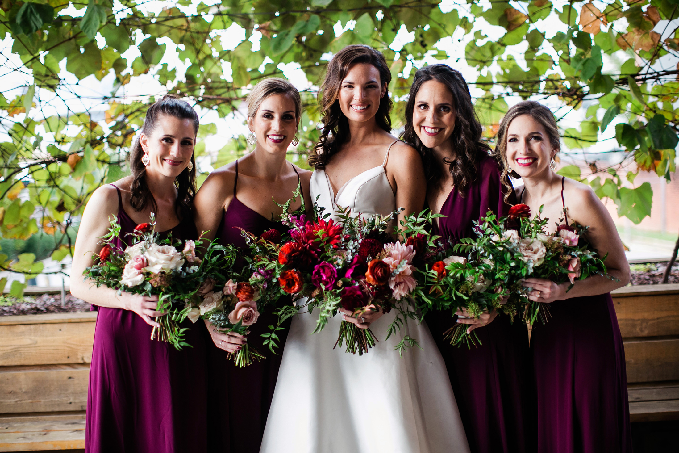 Bridesmaids in burgundy dresses with bouquets of marsala, blush, and greenery / Nashville Wedding Florist