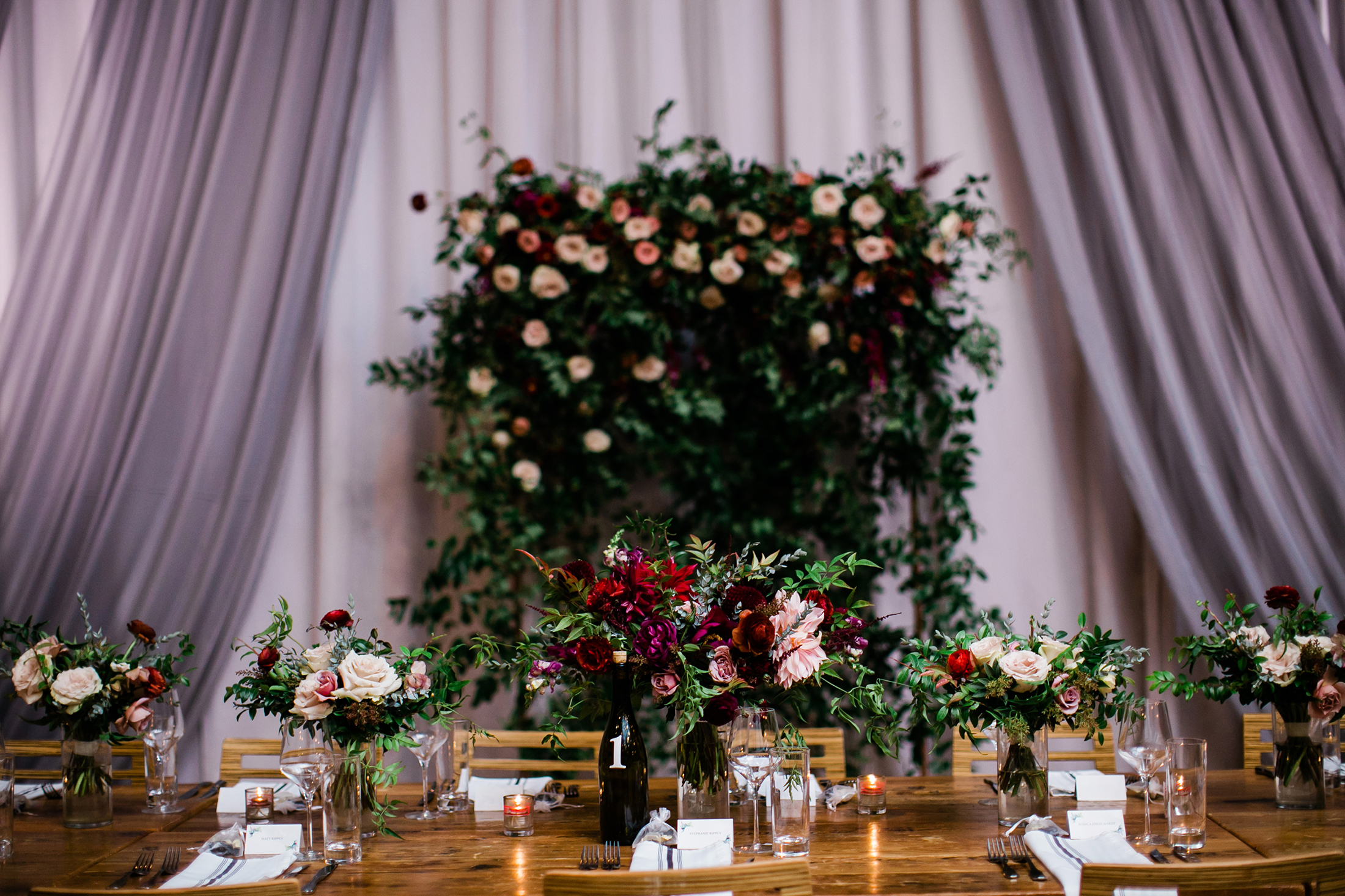 Flower wall for the head table backdrop with lush greenery and burgundy and blush florals // Nashville Wedding Florist