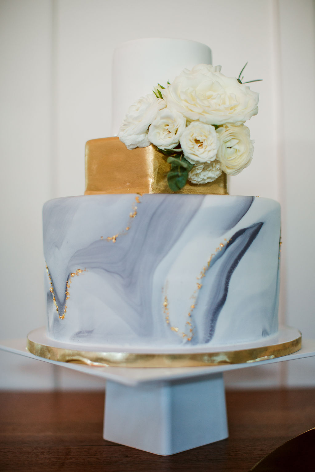 Marbled cake with all white flowers and touches of greenery
