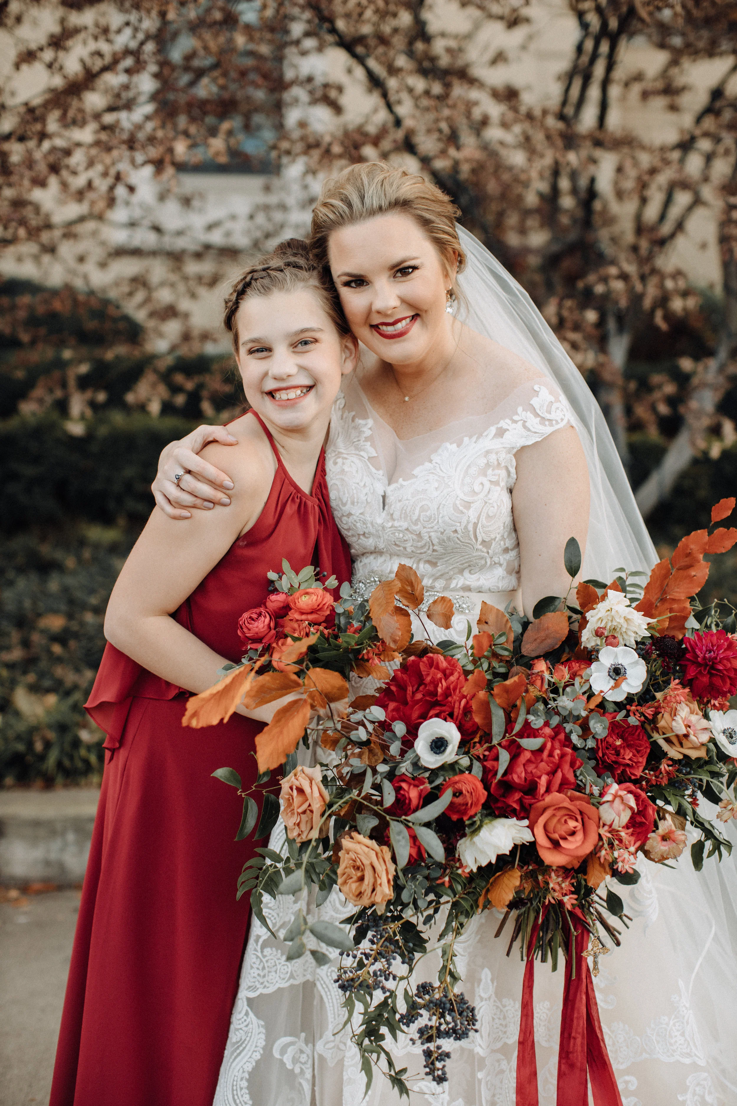 Burgundy velvet bridesmaid dresses with lush, asymmetrical bouquets using garden roses, ranunculus, and anemones