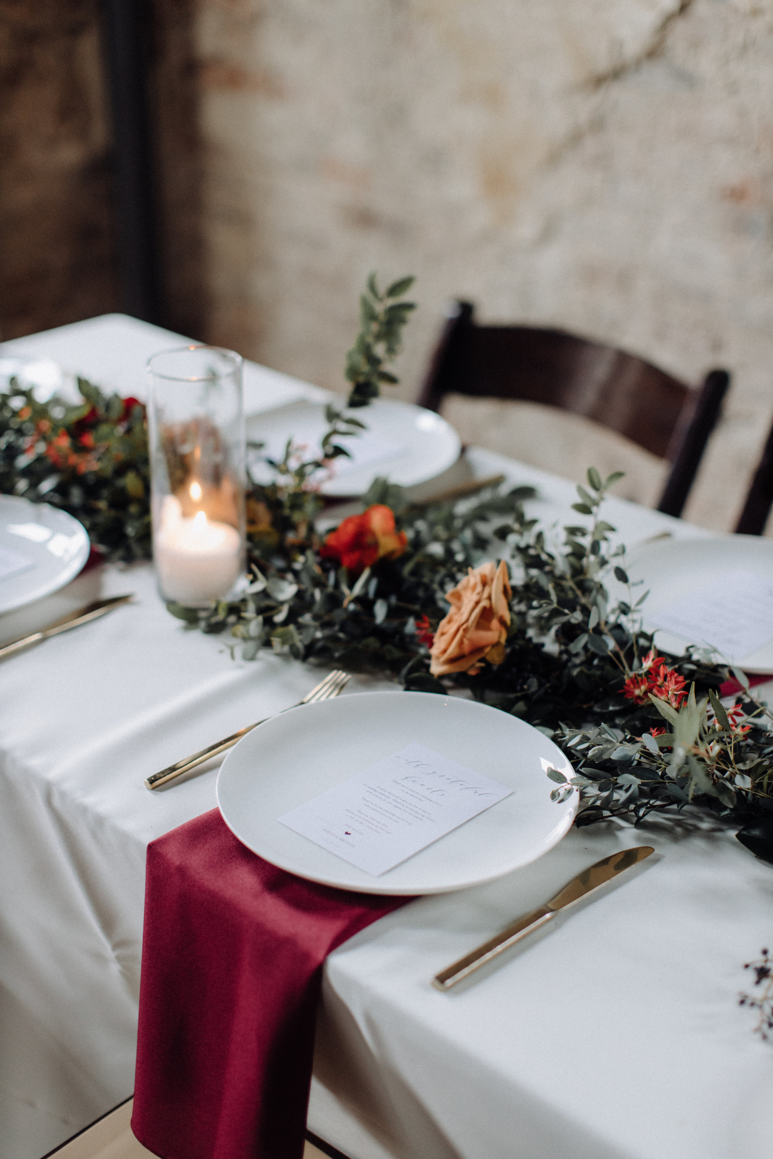 Garland table runner of eucalyptus and natural greenery with copper and burgundy floral accents. Garden-inspired wedding florals at the Cordelle, Nashville.