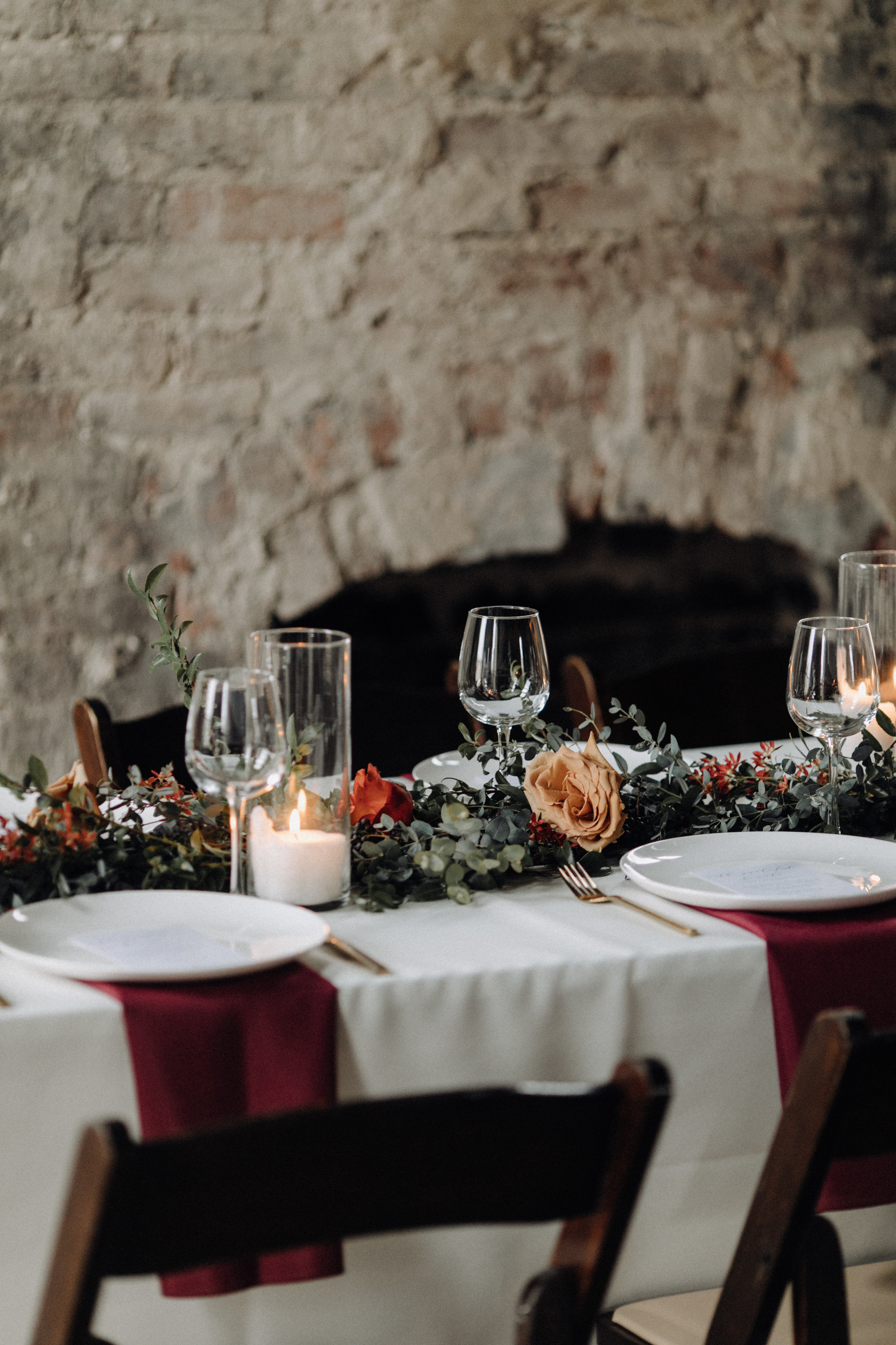 Garland table runner of eucalyptus and natural greenery with copper and burgundy floral accents. Garden-inspired wedding florals at the Cordelle, Nashville.