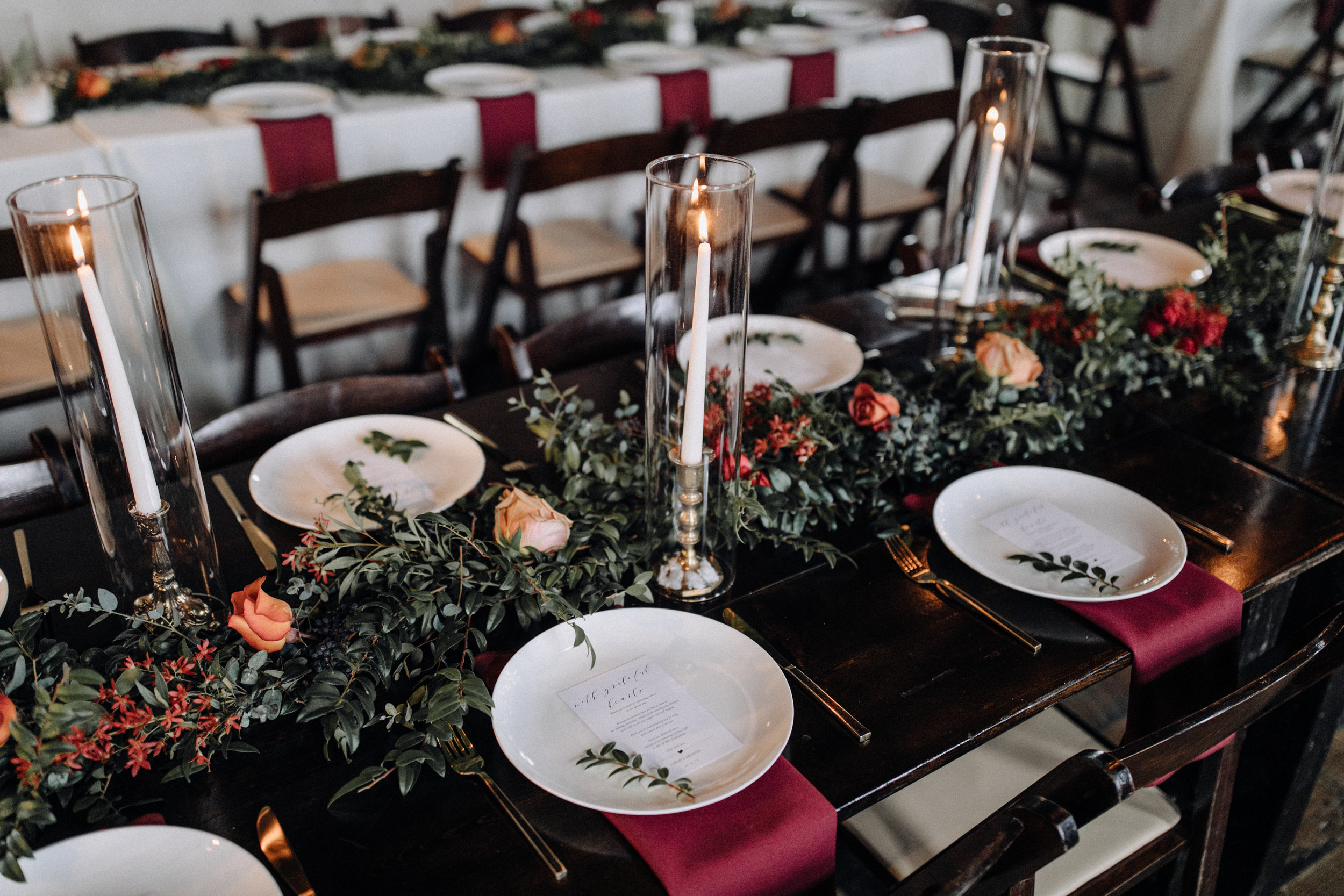 Garland table runner of eucalyptus and natural greenery with copper and burgundy floral accents. Garden-inspired wedding florals at the Cordelle, Nashville.