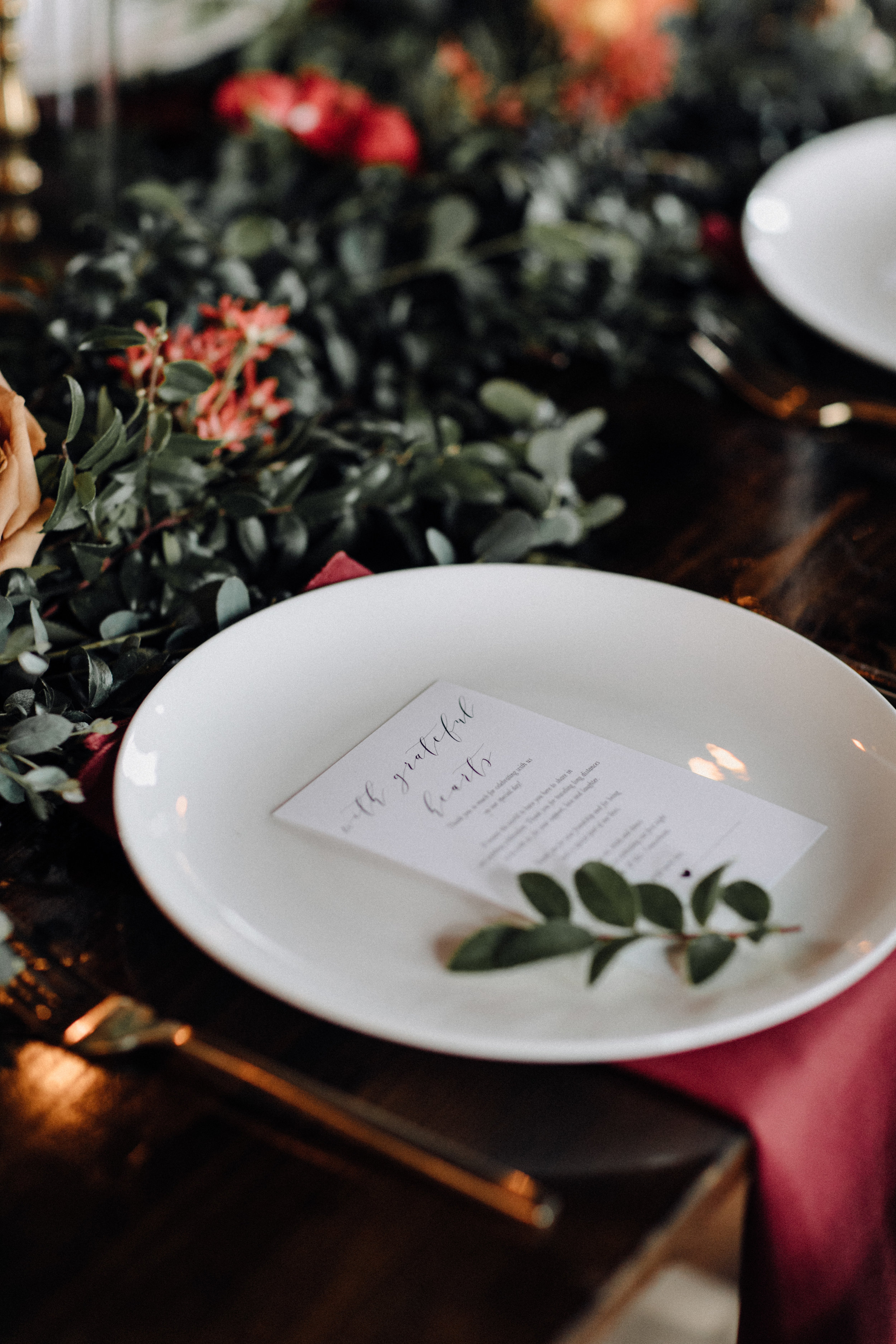 Garland table runner of eucalyptus and natural greenery with copper and burgundy floral accents. Garden-inspired wedding florals at the Cordelle, Nashville.