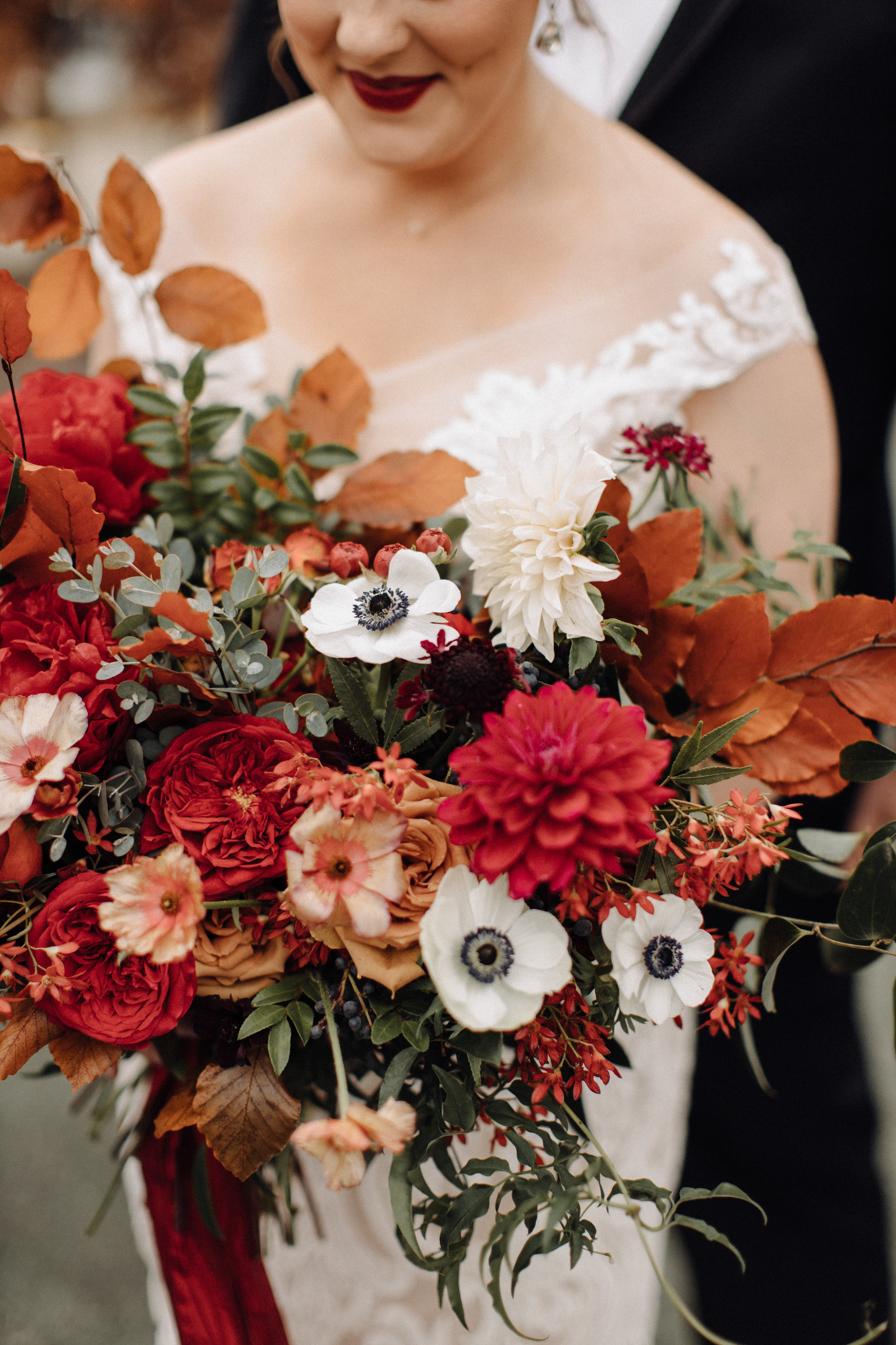 Lush bridal bouquet with autumn foliage, anemones, dahlias, and garden roses. Nashville Wedding Floral Design.