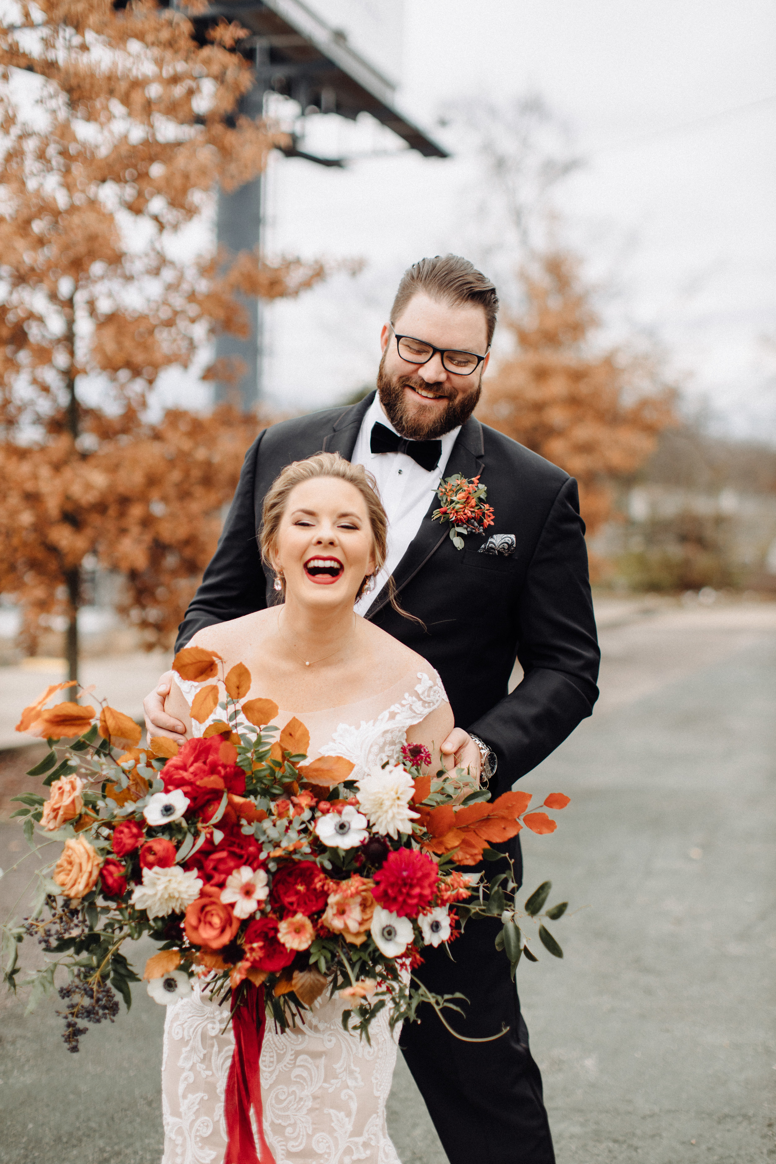 Asymmetrical, airy bridal bouquet with burgundy, burnt orange, and gold hues, using anemones, dahlias, and garden roses. Nashville, TN wedding florist.