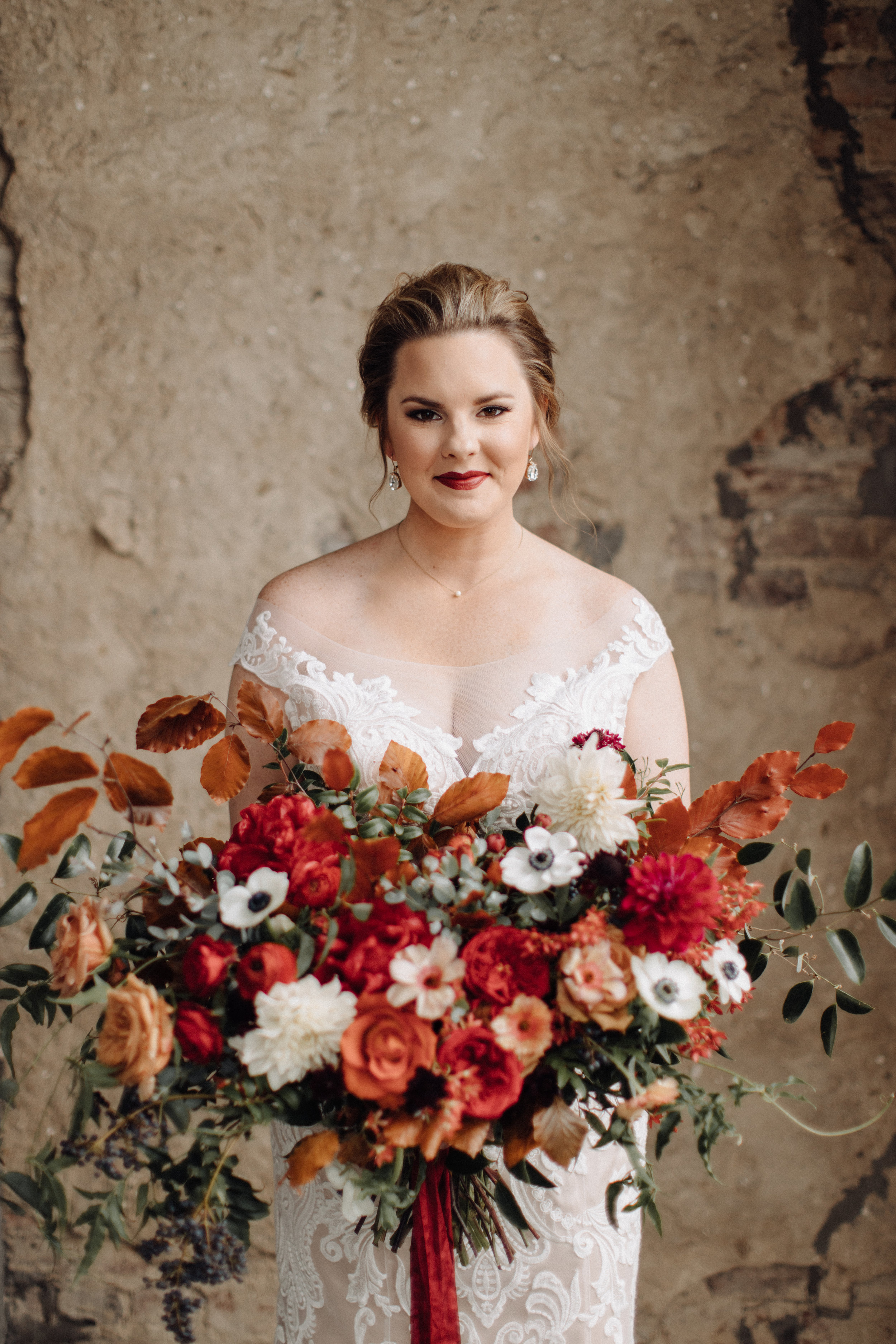 Airy, untamed bride’s bouquet of lush greenery, berries and textures, burgundy  peonies, burnt orange garden roses, anemones, and dahlias. Nashville Wedding Floral Design at the Cordelle.