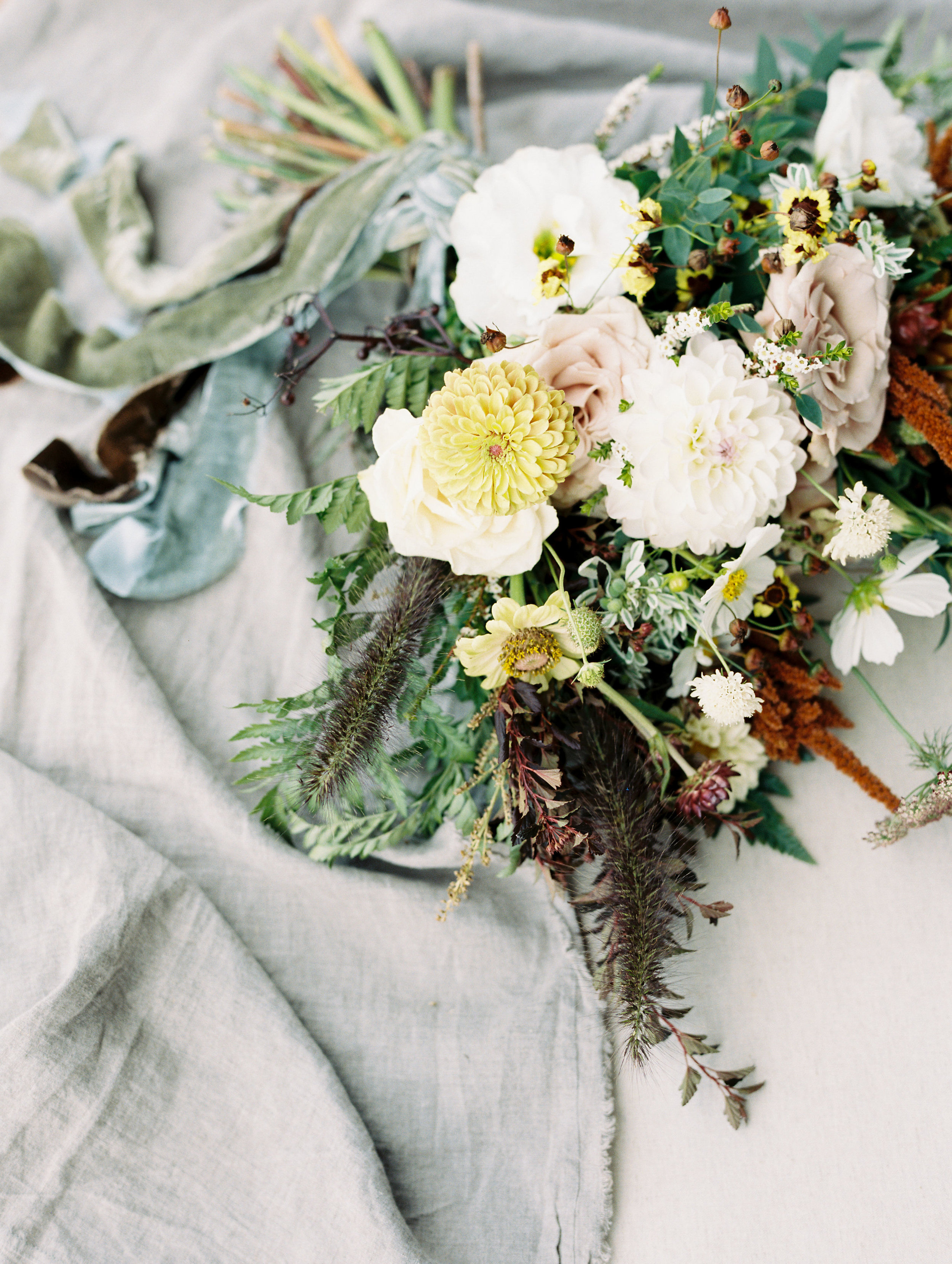 Lush bridal bouquet in muted hues with wildflowers, greenery, and garden roses. Tennessee Wedding Florist.