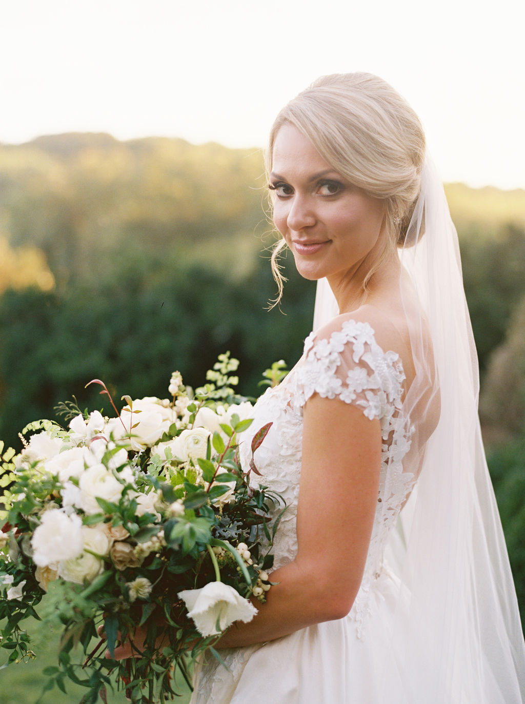 Untamed, asymmetrical bride’s bouquet with all white flowers and natural greenery. Southeast US Wedding Floral Design.