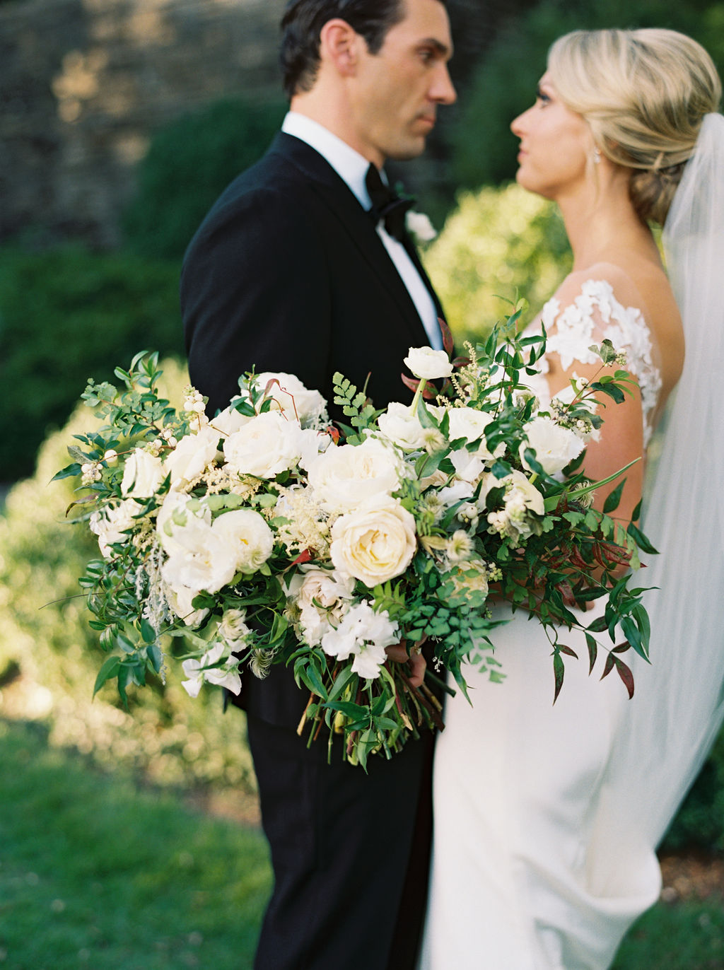 Natural, organic bridal bouquet with white garden roses, ranunculus, and lush greenery. Nashville, TN Wedding Florist.