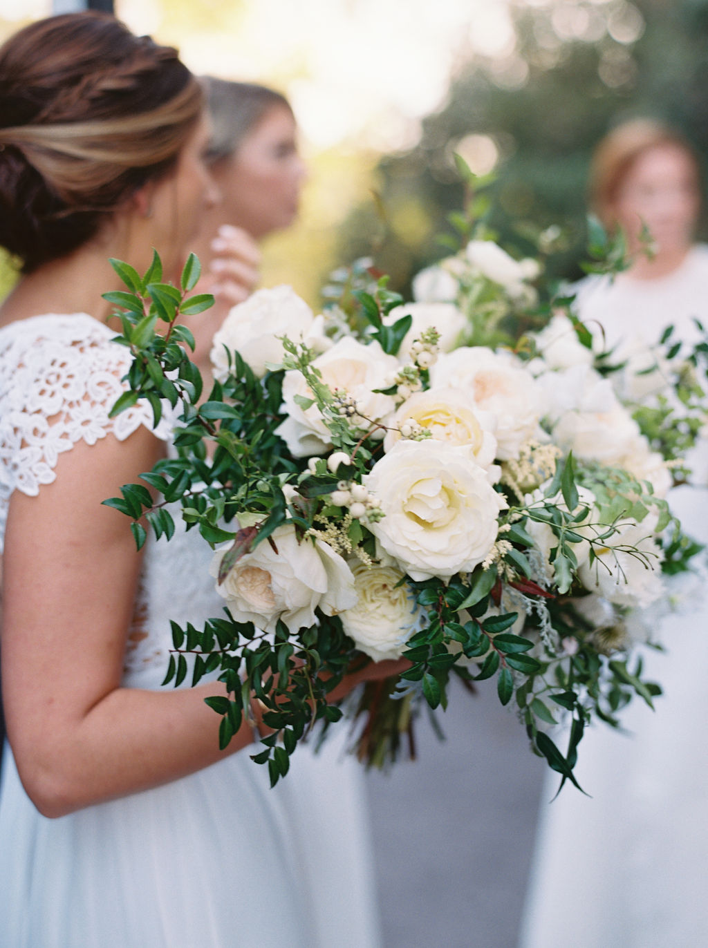 All white bridesmaid dresses with white flowers and greenery. Nashville Wedding Floral Design.