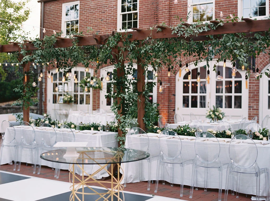 Wooden garden trellis over the head table with natural, vine-like greenery and floral garlands. Nashville Wedding Florist.