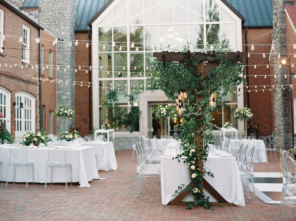 Wooden garden trellis over the head table with natural, vine-like greenery and floral garlands. Nashville Wedding Florist.