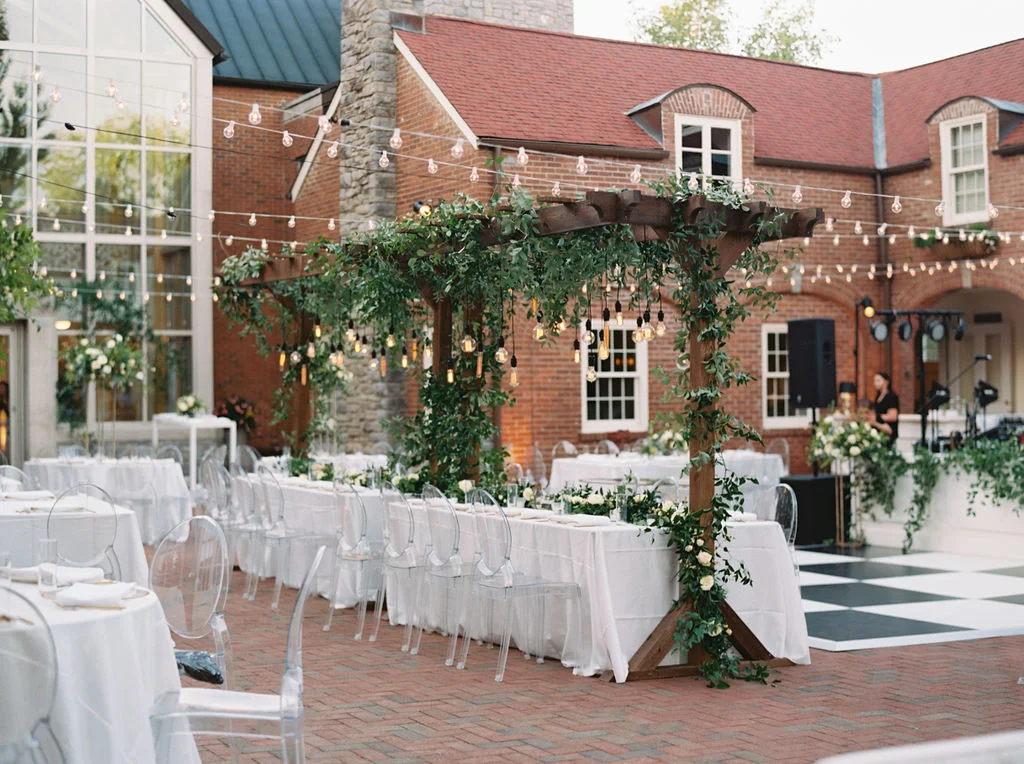 Wooden garden trellis over the head table with natural, vine-like greenery and floral garlands. Nashville Wedding Florist.