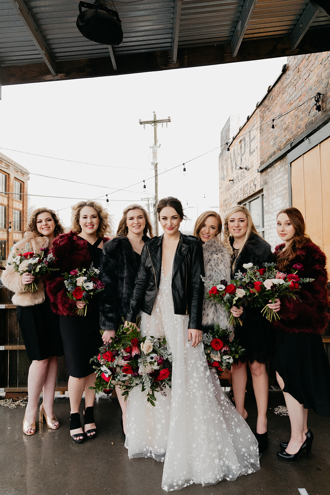 Burgundy, eggplant, and blush bouquets with black bridesmaid dresses and the bride in a leather jacket! Badass Nashville wedding florals.