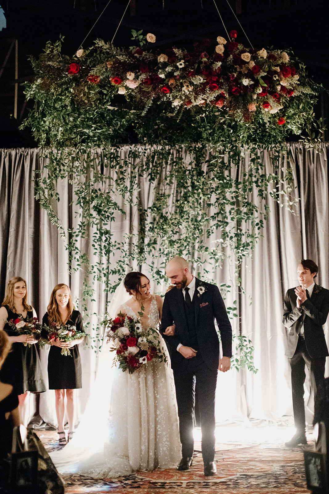 Oversized wreath floral installation with eggplant and burgundy florals and a curtain of greenery. Nashville Wedding Floral Design.