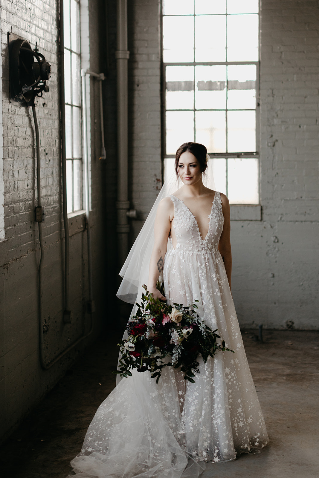 Starry wedding dress with an untamed, airy bridal bouquet with garden roses, ranunculus, and anemones in hues of burgundy and jewel tones.