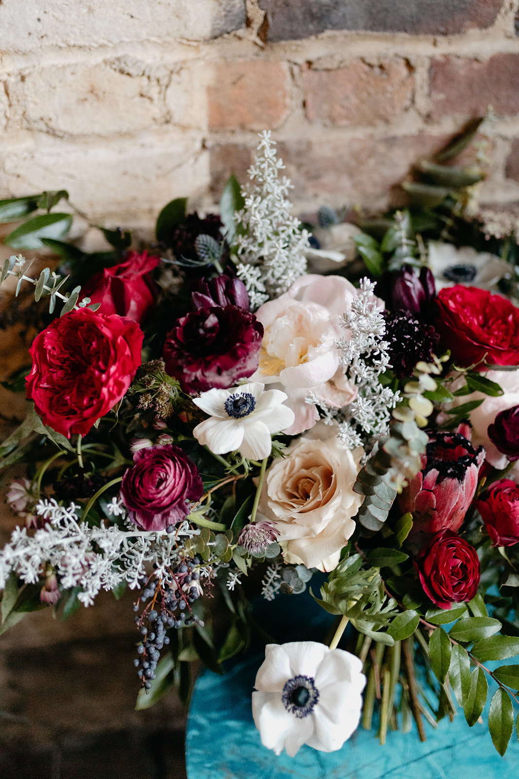 Lush, wintry bridal bouquet with garden roses, anemones, ranunculus, and greenery. Nashville Wedding Florist.