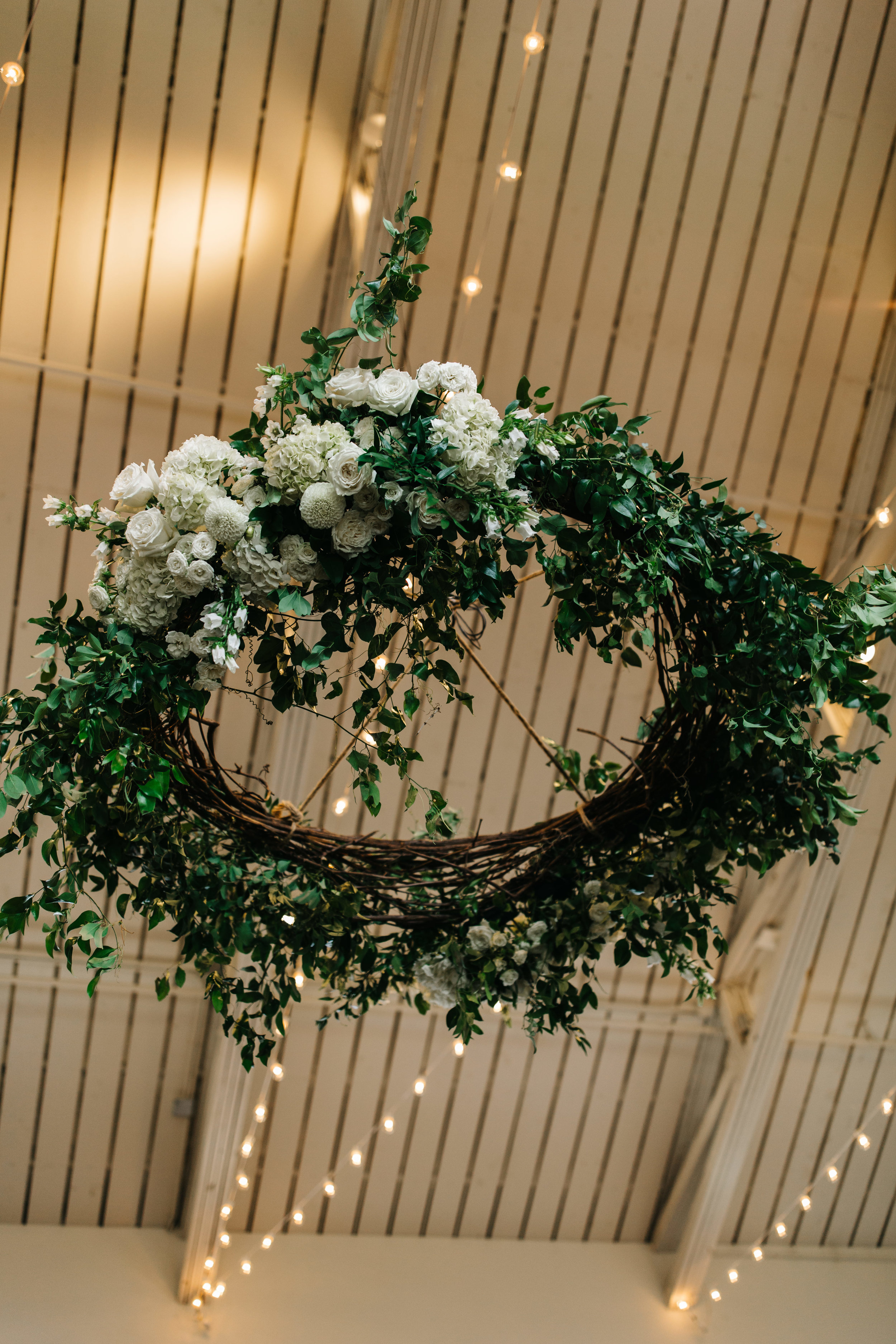 Lush greenery chandelier with all white florals over the dance floor. Nashville Wedding Florist.