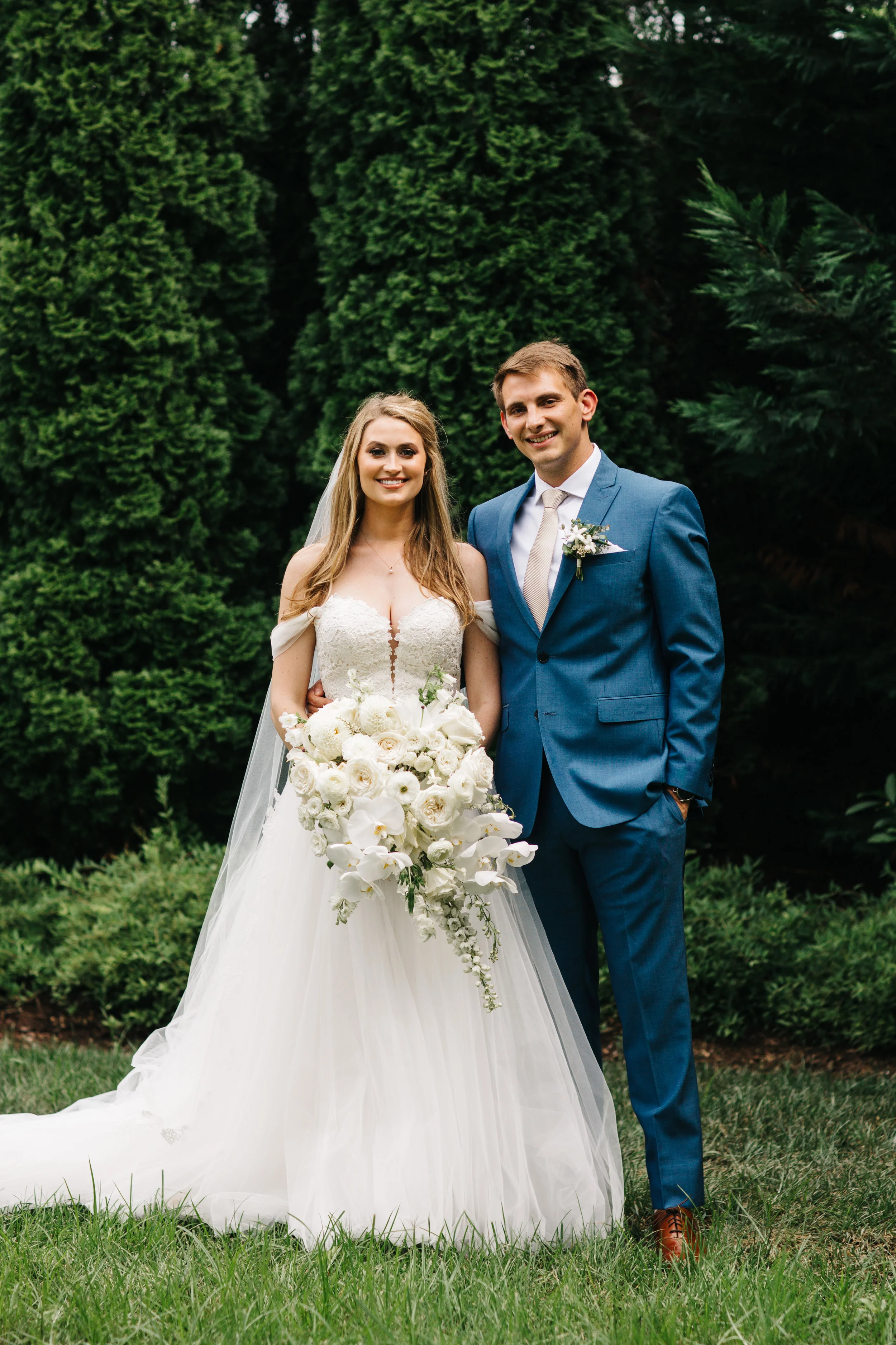 All white, cascading bridal bouquet with orchids, garden roses, and ranunculus. Nashville Wedding floral design at the Cordelle.