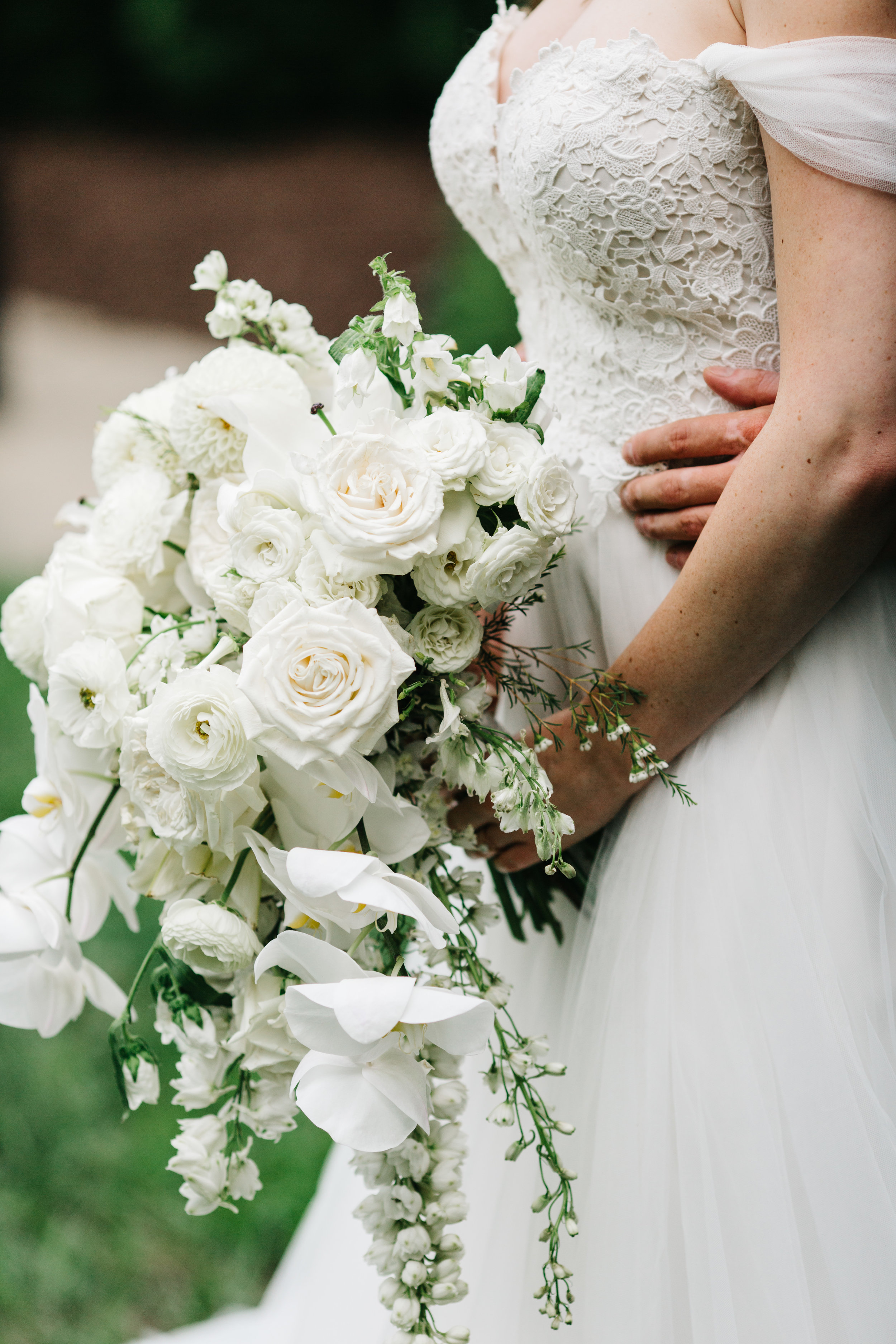 All white, cascading bridal bouquet with orchids, garden roses, and ranunculus. Nashville Wedding floral design at the Cordelle.