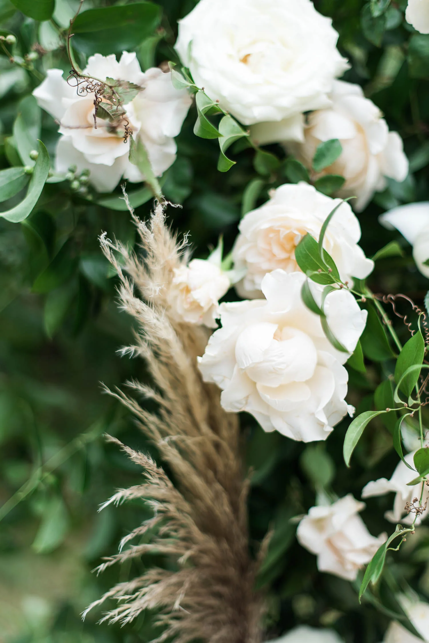 Lush wedding arch with untamed greenery, garden roses, textures, and antlers. Nashville Wedding Florist.