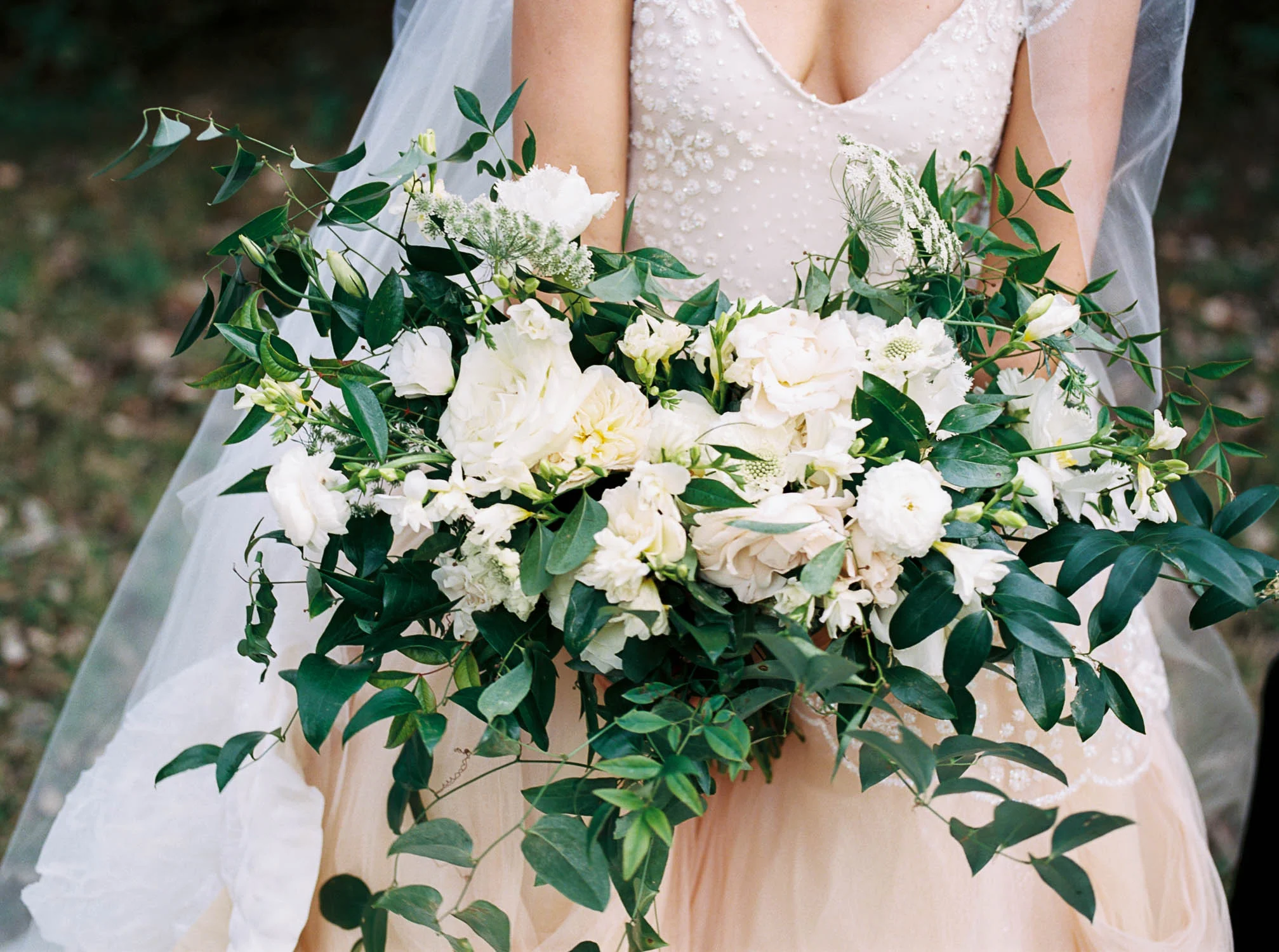 Blush wedding dress with asymmetrical, trailing floral design in Nashville, TN.
