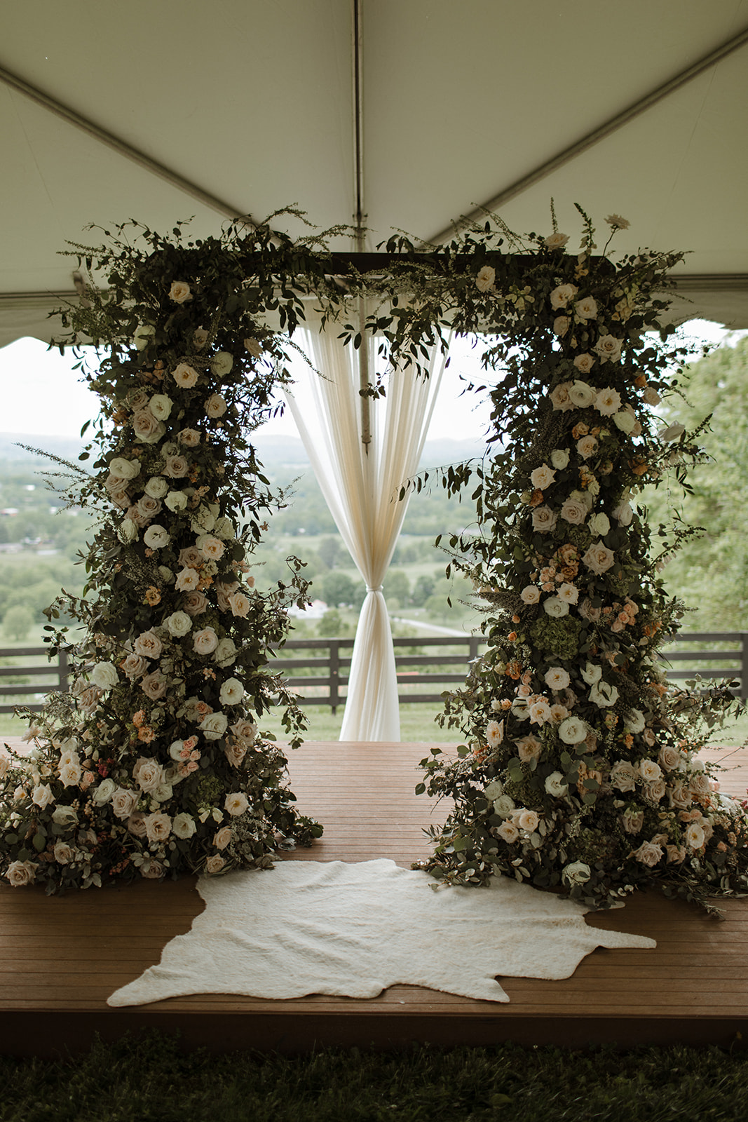 Untamed, lush wedding arch with natural greenery and blush and ivory flowers. Nashville Wedding Floral Design.