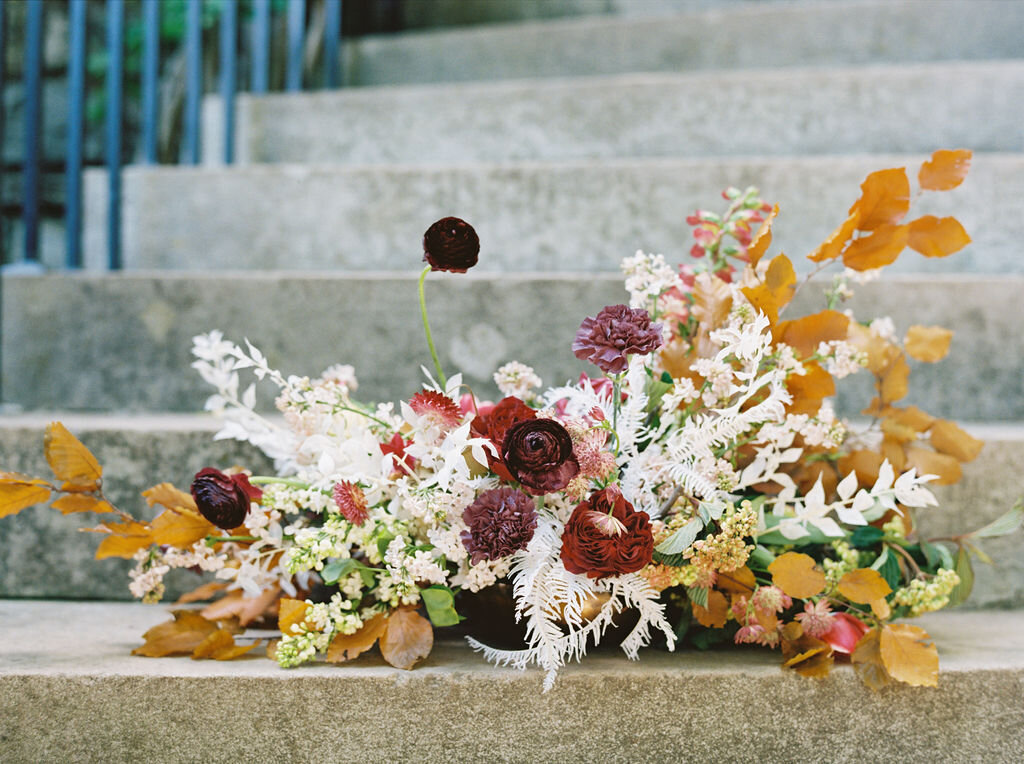 Low centerpiece with a mauve, rust, and burgundy color palette for an Indian wedding at Cheekwood Botanical Gardens. Nashville Wedding Florist.