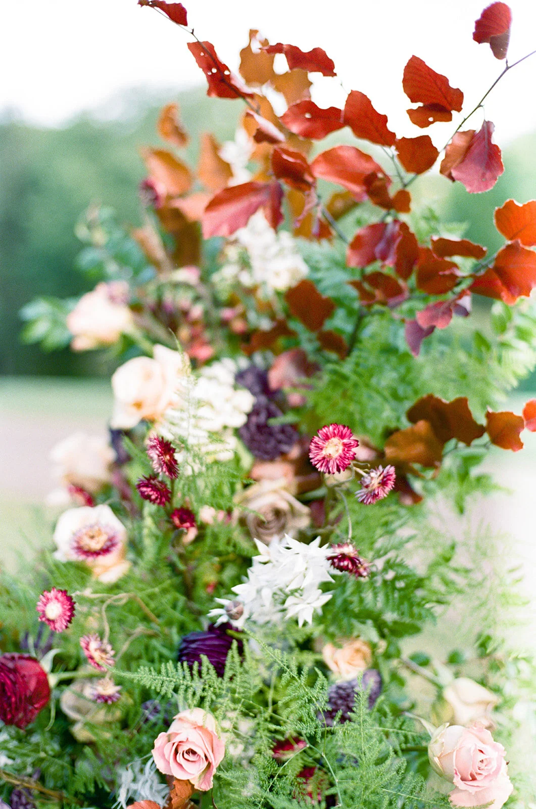 Freestanding wedding ceremony backdrop with lush greenery and a bright flowers. Nashville wedding floral design by Rosemary & Finch.