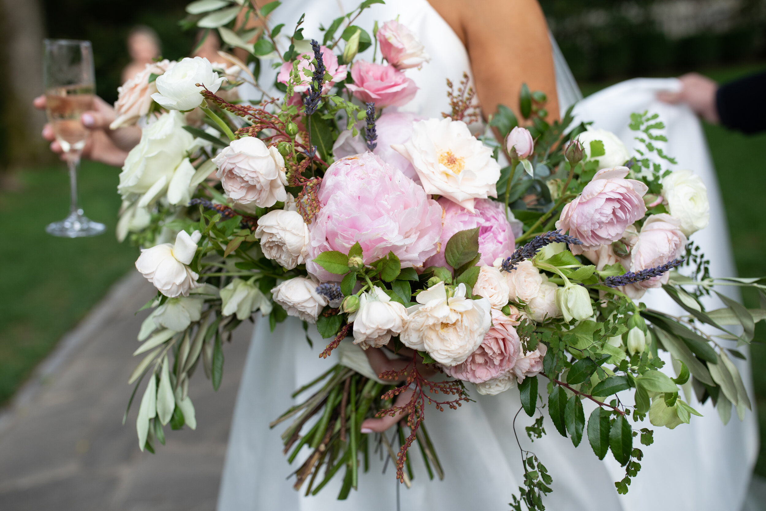 Loose, untamed bridal bouquet with soft pink peonies, white garden roses, ranunculus, olive branches, ferns, and greenery. Nashville wedding and event floral design at Belle Meade Plantation.