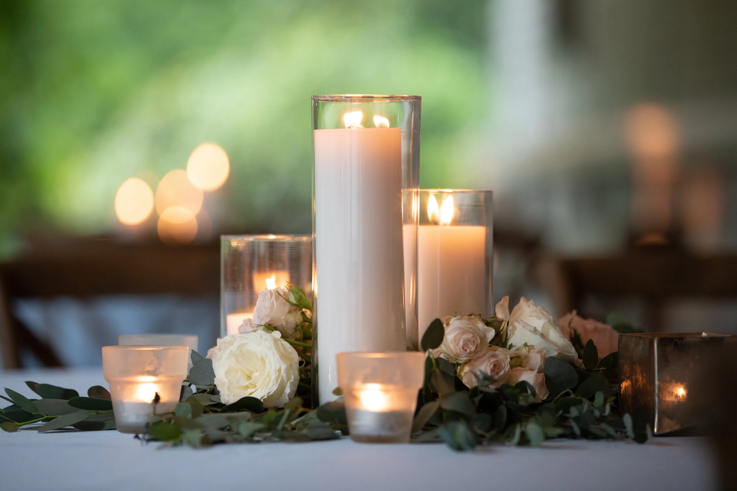 Pillar candle centerpieces with lush greenery and blush and ivory flowers. Belle Meade Plantation wedding florist.