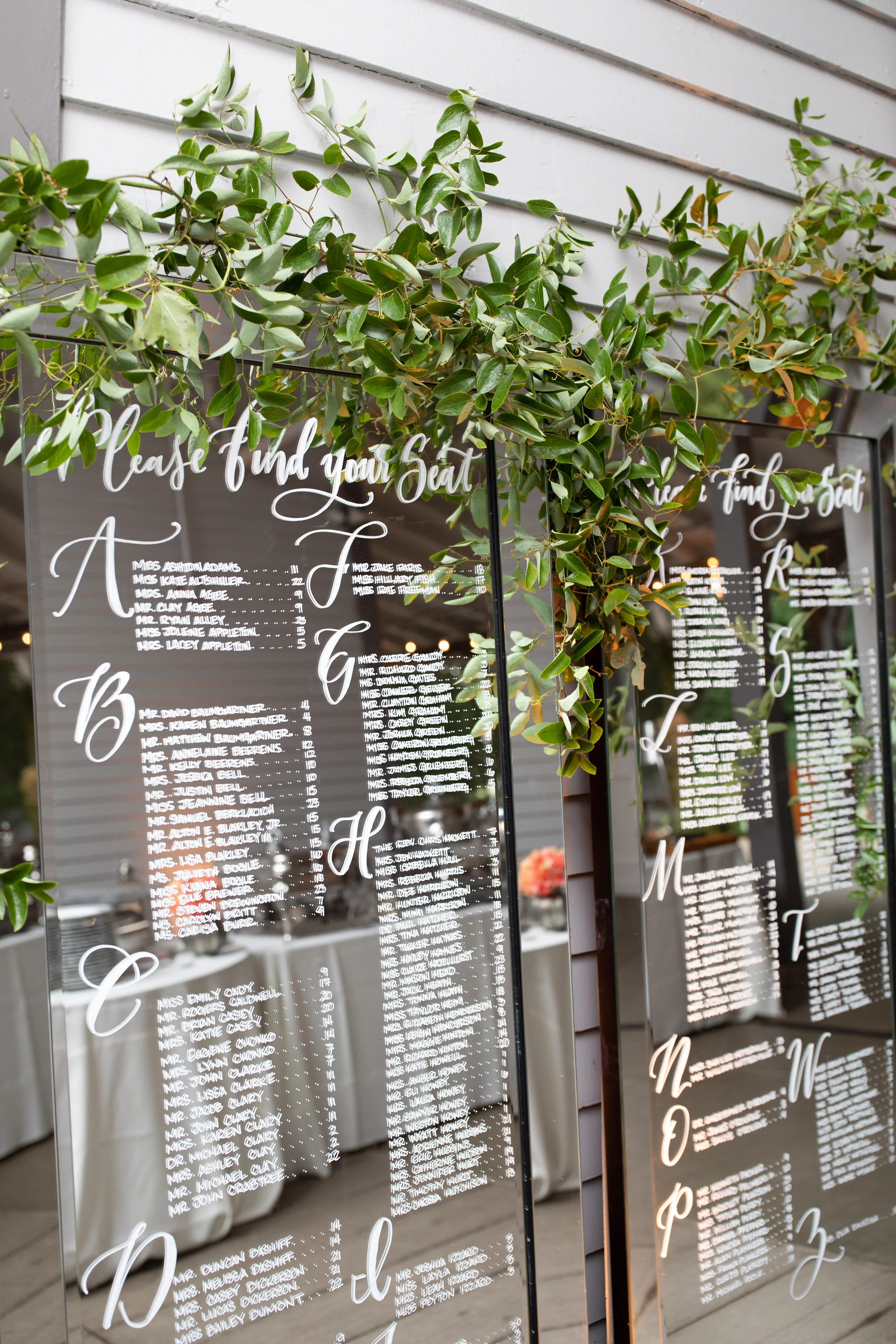 Double chandelier with vines and lush greenery with blush and white flower accents. Nashville luxury wedding and event floral design.