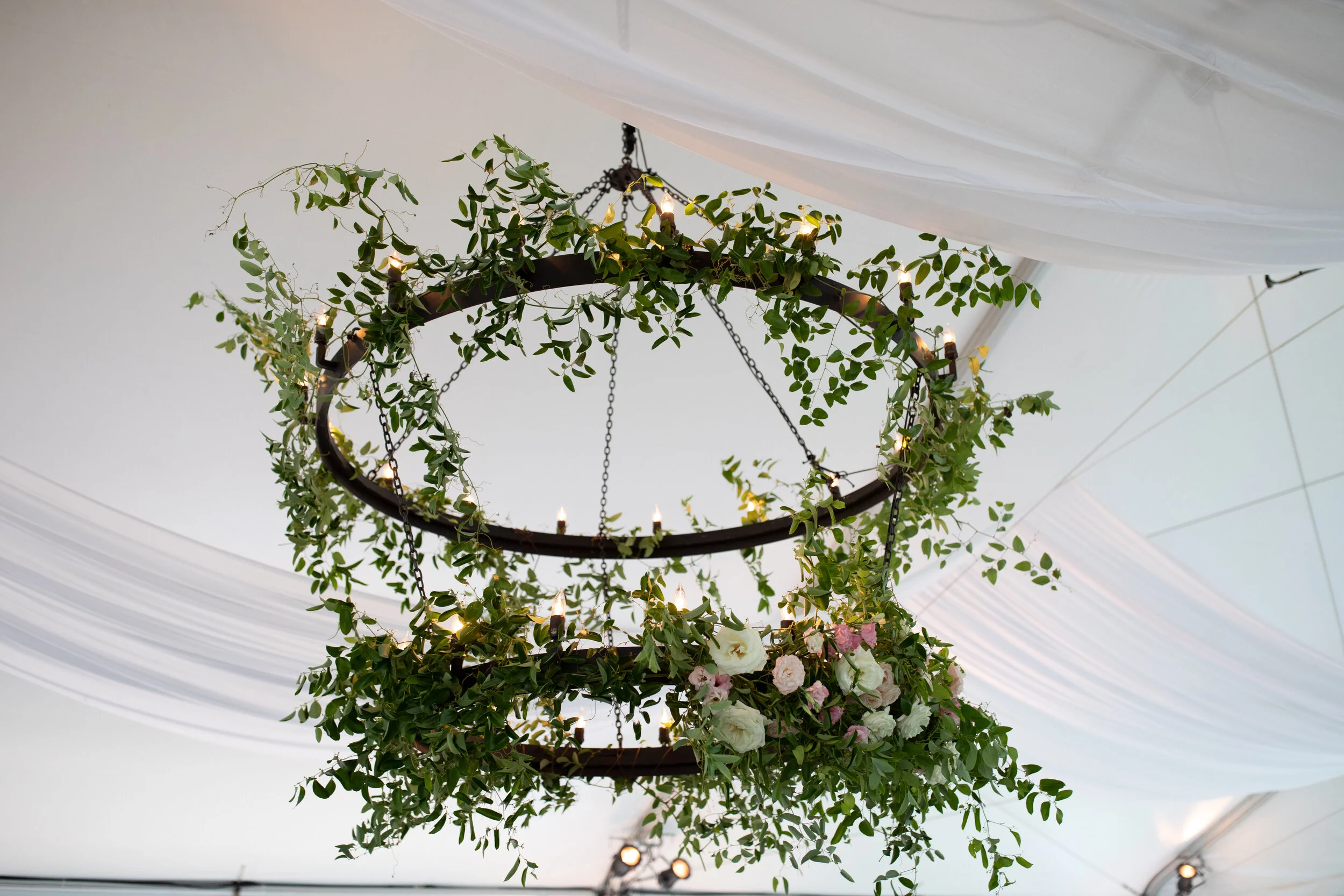 Double chandelier with vines and lush greenery with blush and white flower accents. Nashville luxury wedding and event floral design.