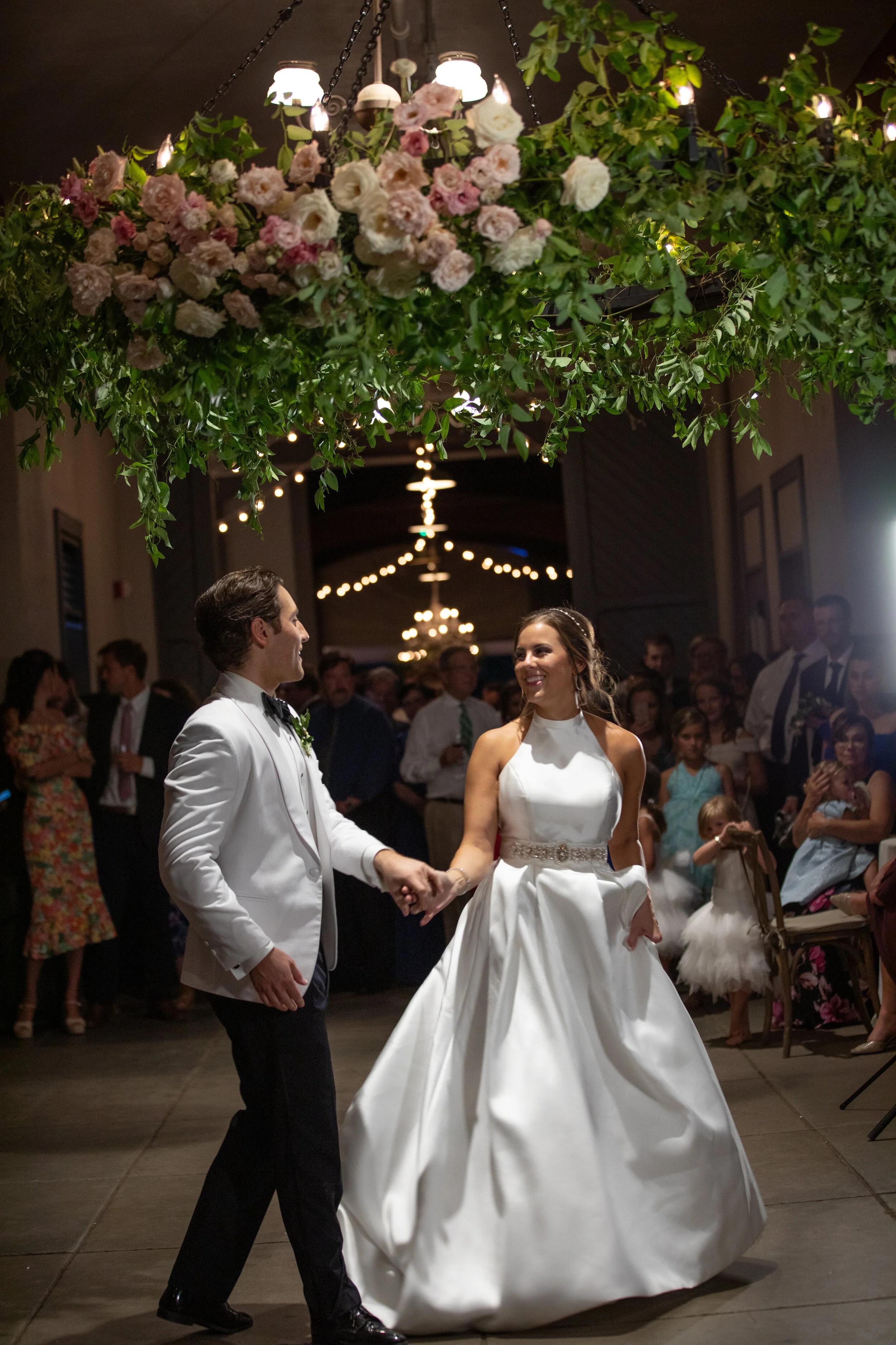 Oversized floral wreath installation over the dance floor with lush vines and greenery with blush and white flowers. Nashville event and wedding florist at Belle Meade Plantation.