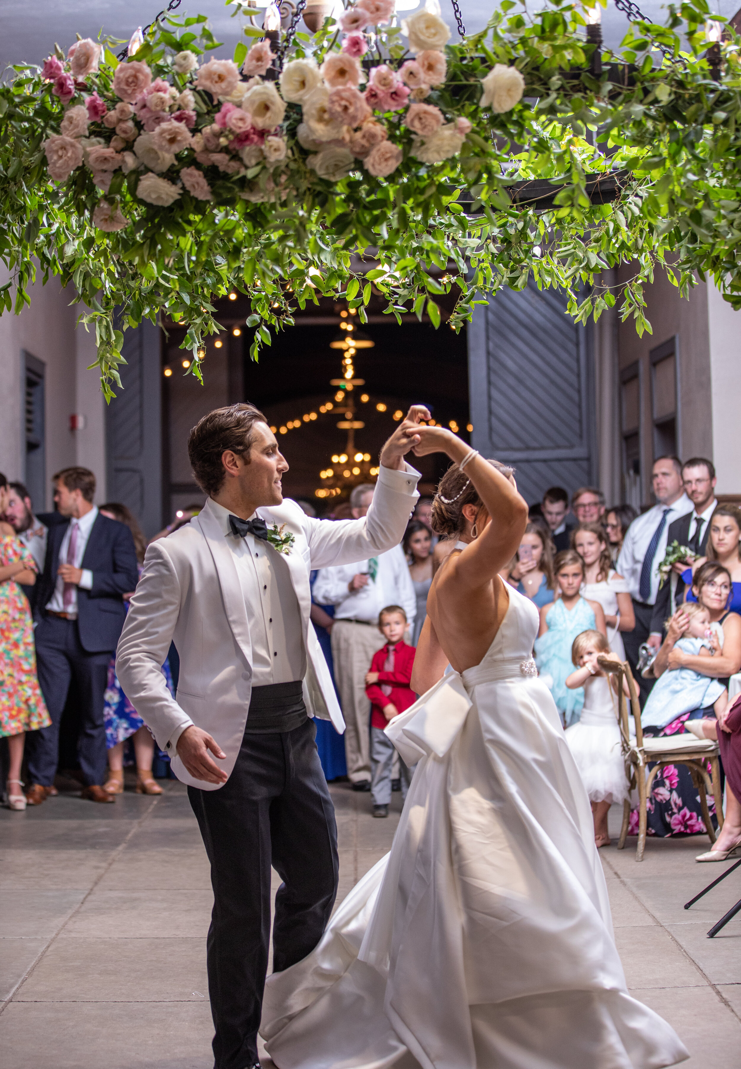 Oversized floral wreath installation over the dance floor with lush vines and greenery with blush and white flowers. Nashville event and wedding florist at Belle Meade Plantation.