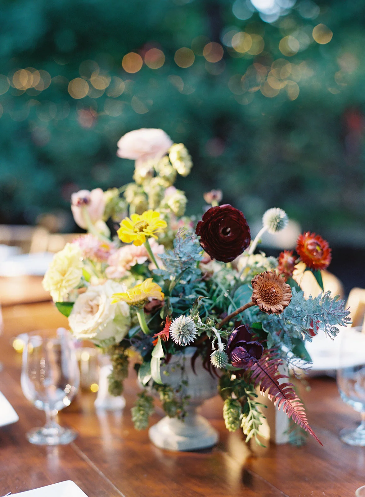 Welcome dinner on the front drive with wildflower centerpieces using ranunculus, chinos, hops, blackberries, persimmons, hops, garden roses, and natural, asymmetrical greenery. RT Lodge and Nashville wedding florist.